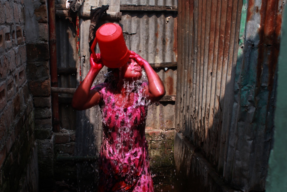A prostitute washes holy colors...n the banks of the Padma River.