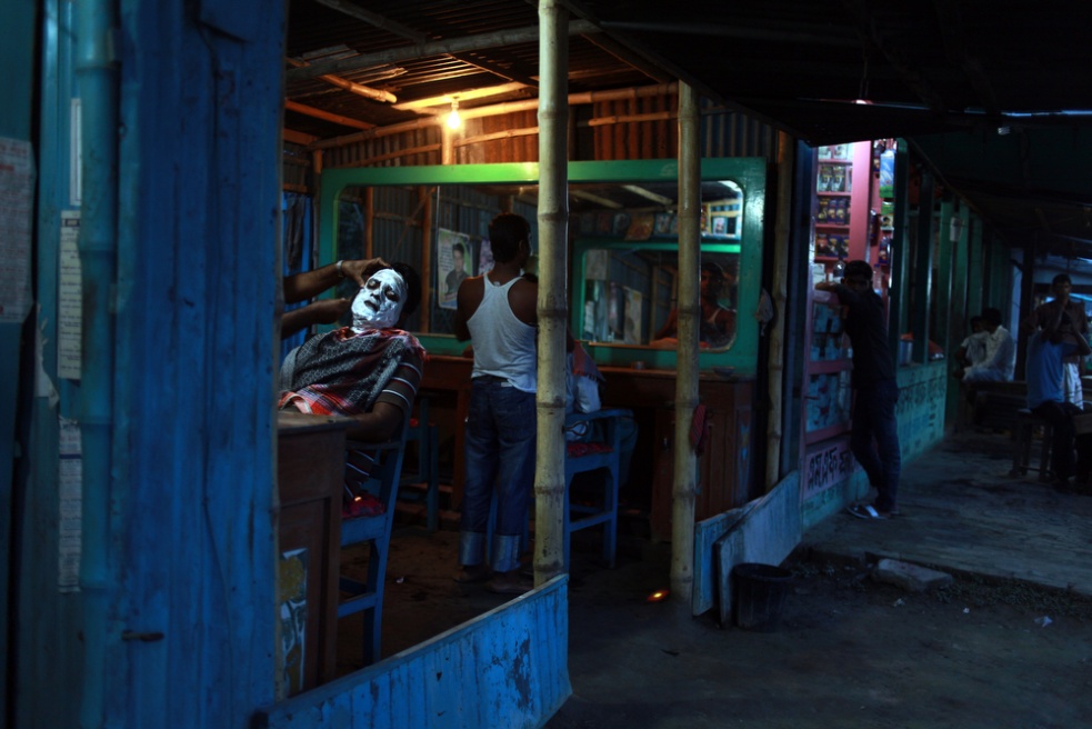 A man gets a shave outside the ...n the banks of the Padma River.