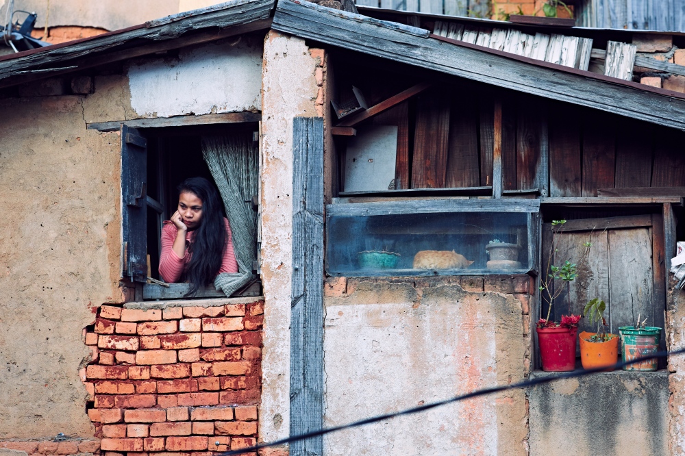 A young woman peers out her window in central Antananarivo.