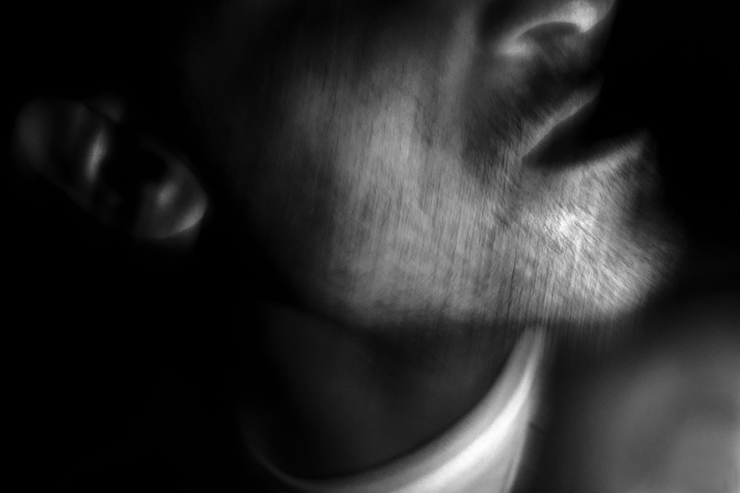  The blurred profile of a man emerges from the darkness that confuses his features while his mouth pronounces disconnected phrases. 