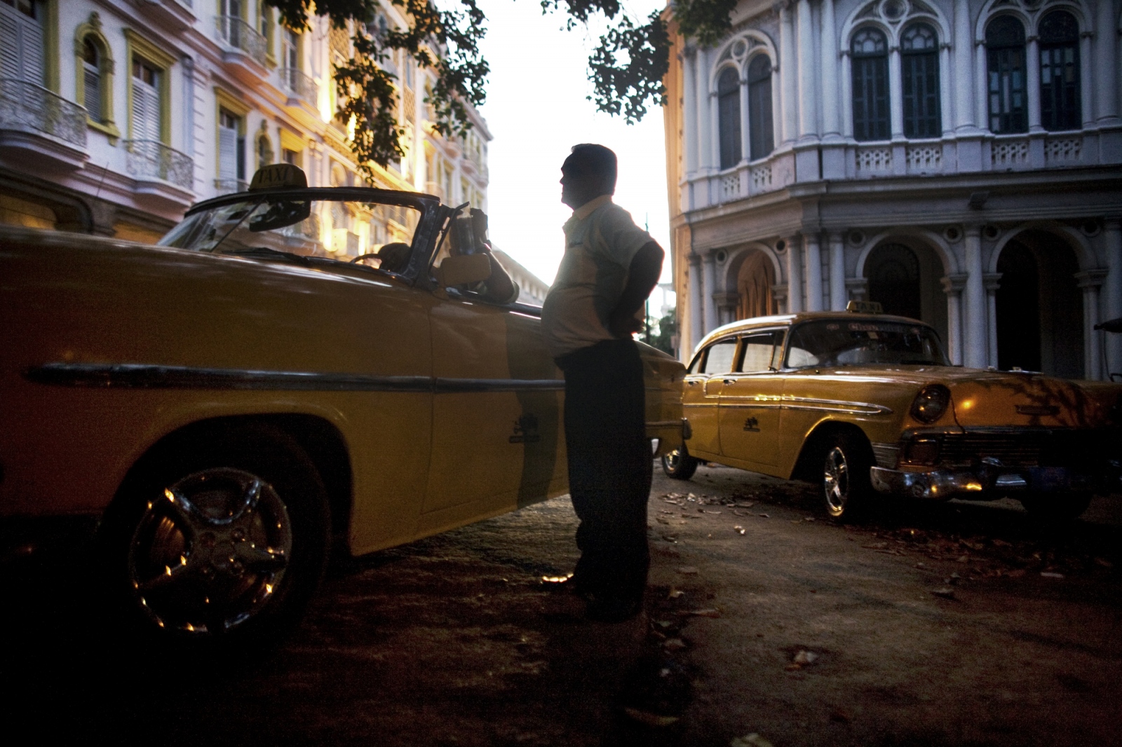 Â¡Cuba Libre! - State employed taxi drivers wait for fares in Havana...