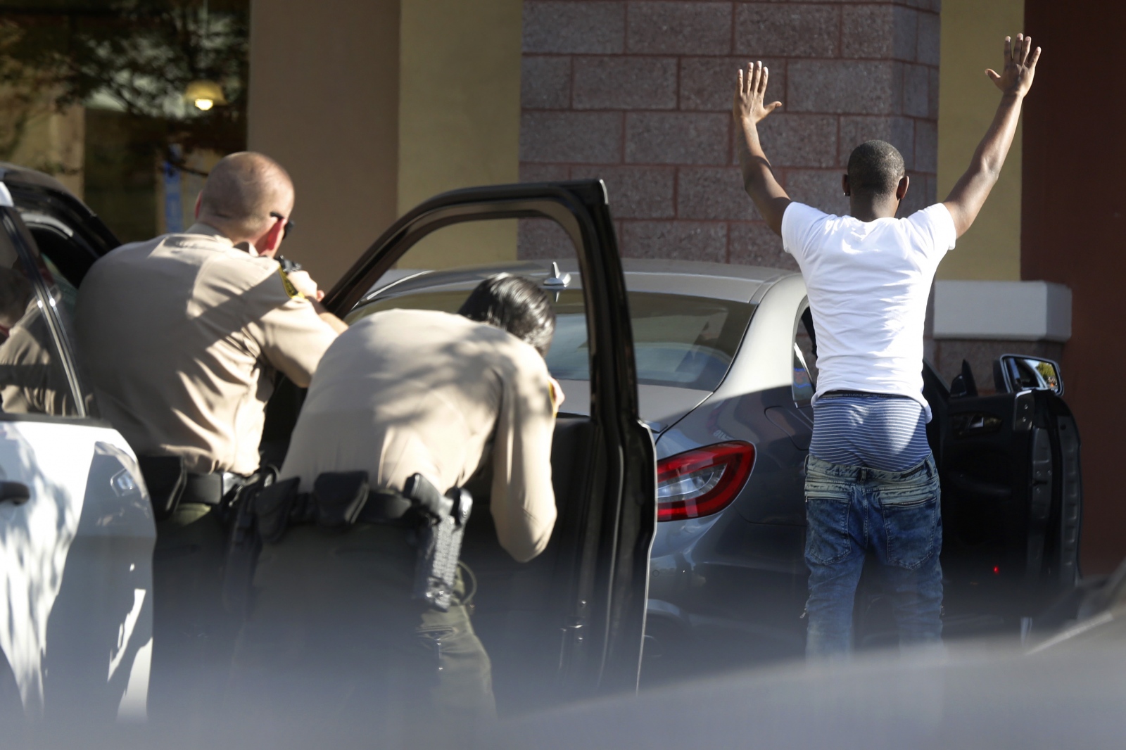 Santa Clarita Valley Sheriff's deputies hold the occupant of a car at gunpoint as they...