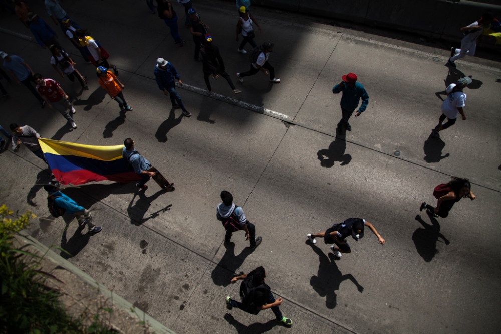 Protesters run away from the Na...as Maduro in Caracas, Venezuela