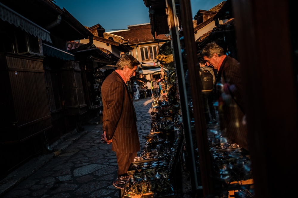 A man looks at items for sale a...r tourism industry in Sarajevo.