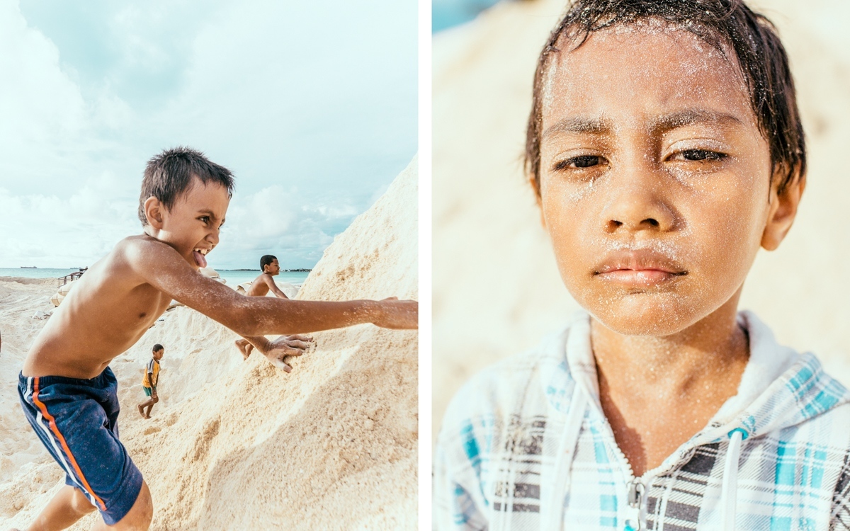 Home - Children play on sand dredged from the lagoon that will...