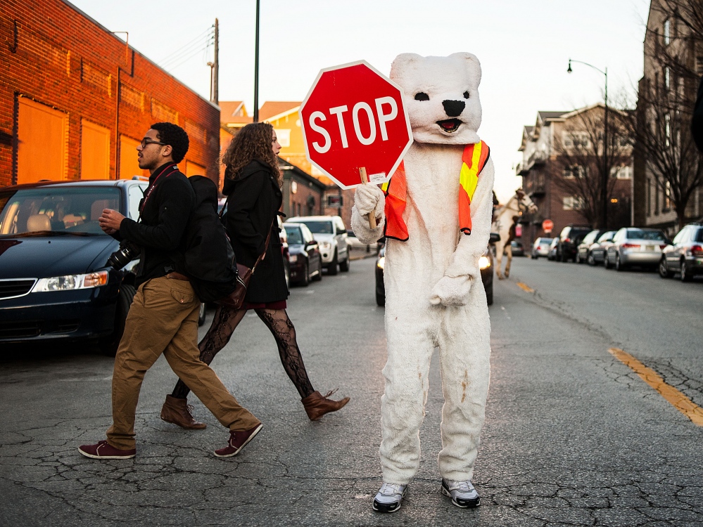  A bear stops traffic to let pedestrians cross along Ninth Street in Columbia, Mo., during the annual True/False documentary film festival. 