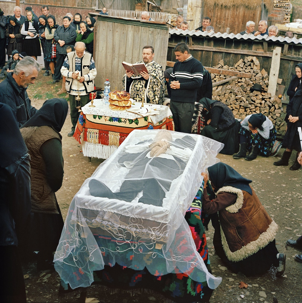 Transylvania: Built on Grass -  Maria Covaci kneels at her husbandâ€™s coffin in the...
