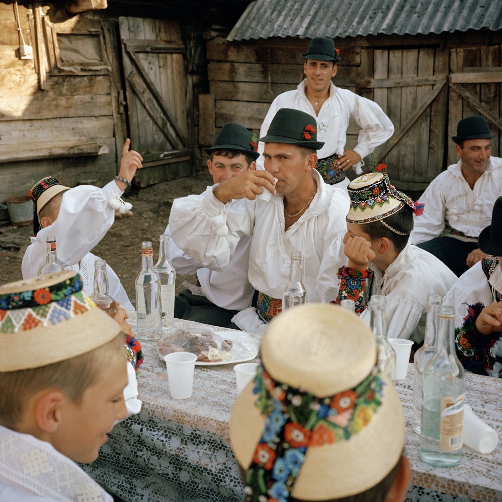 Transylvania: Built on Grass -  Men drinking palinka (distilled plum brandy) shots at...