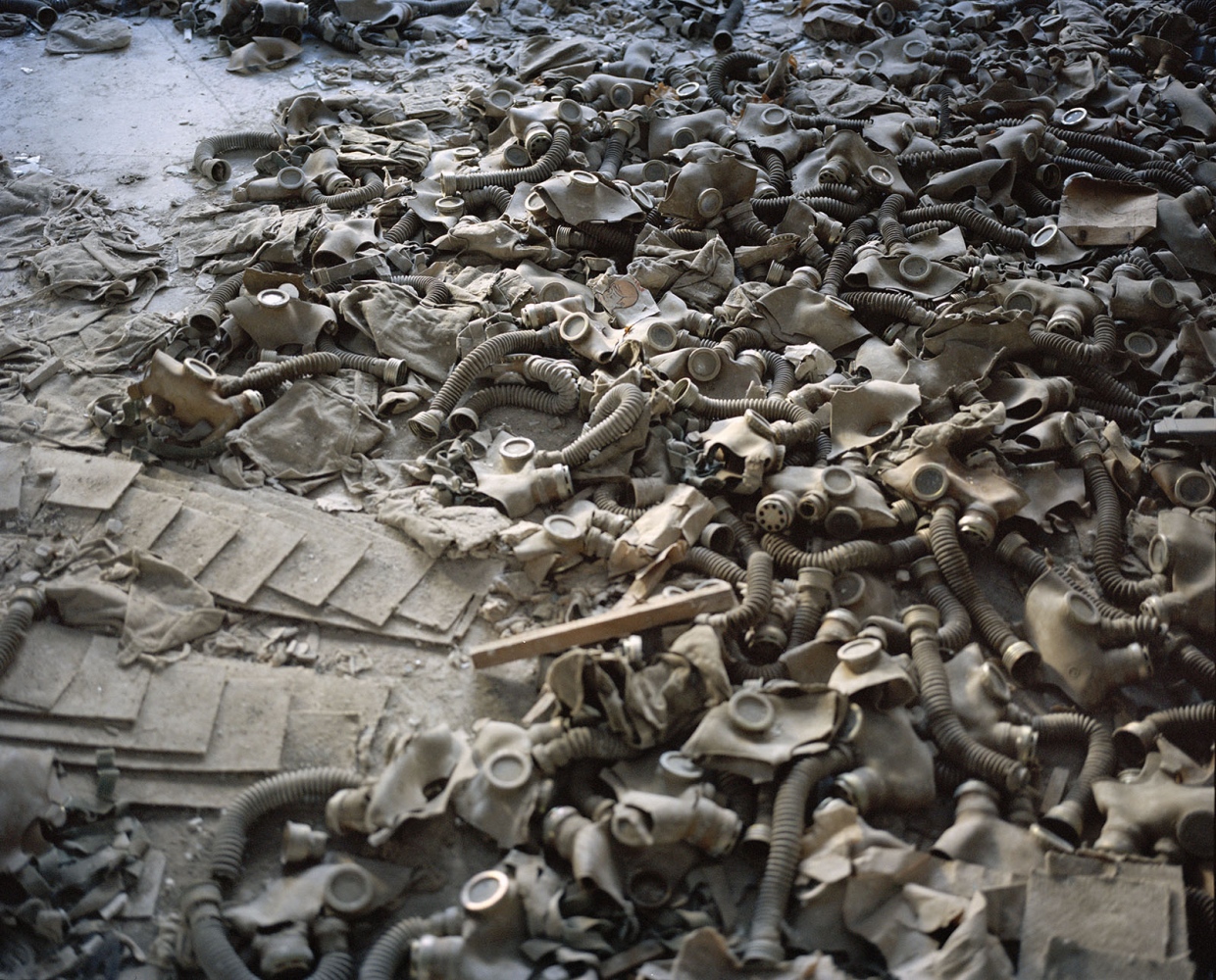 Chernobyl: Still Life in the Zone  - Gas masks scattered on the floor of a school lobby in the...