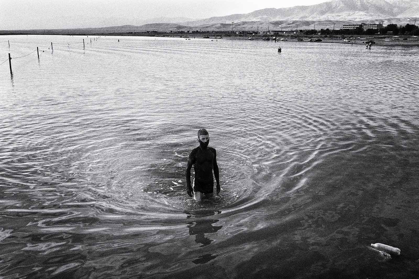 The (Once) Great Salt Lake -  A man is going out of the lake after rubbing sludge on...