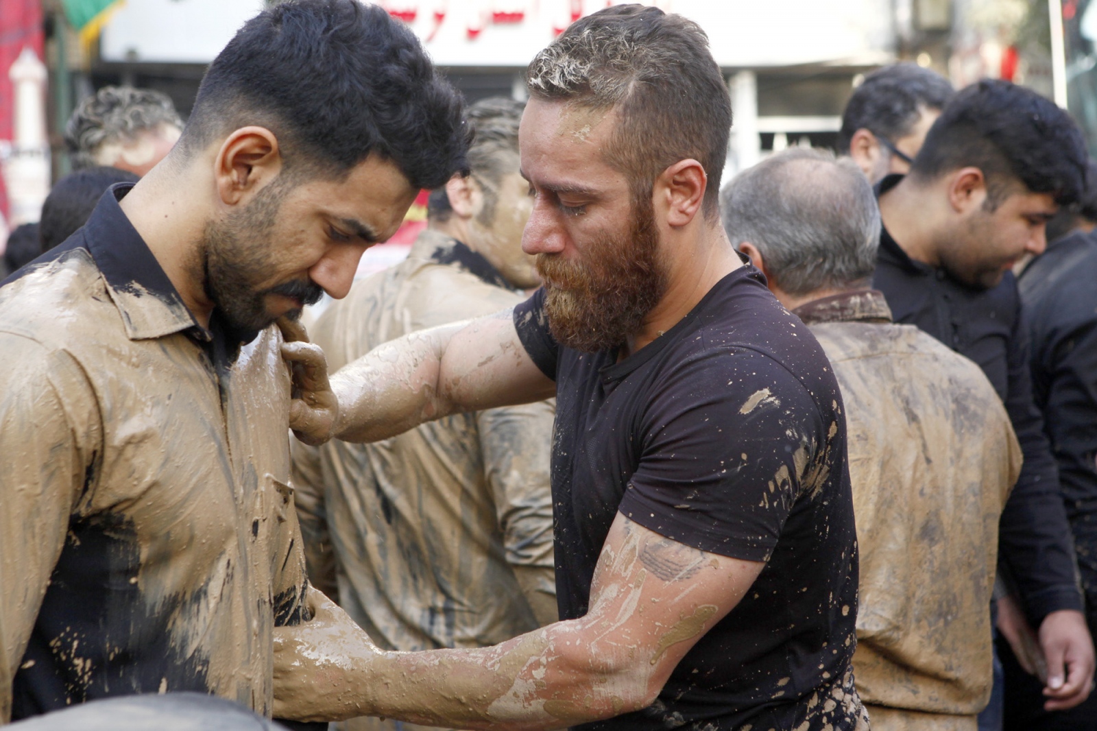 people help each other to get covered by mud.