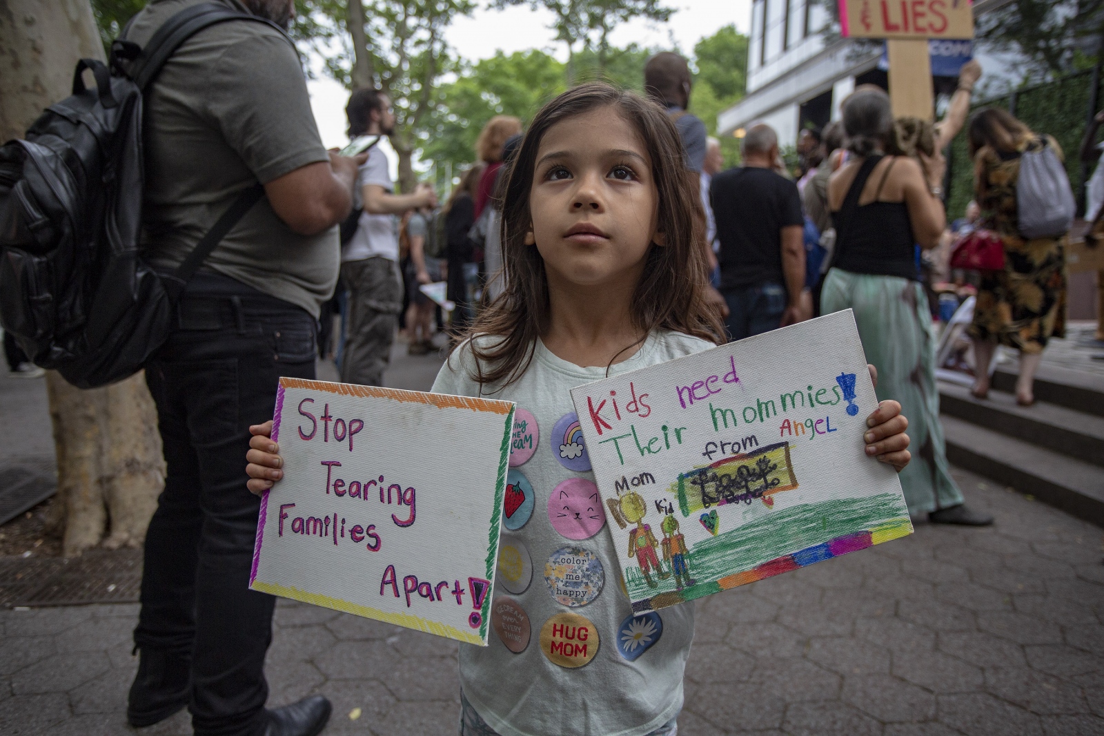 Image from Looking for America -  Tales from Trumpland, Angel, Age 6 holds up two signs...