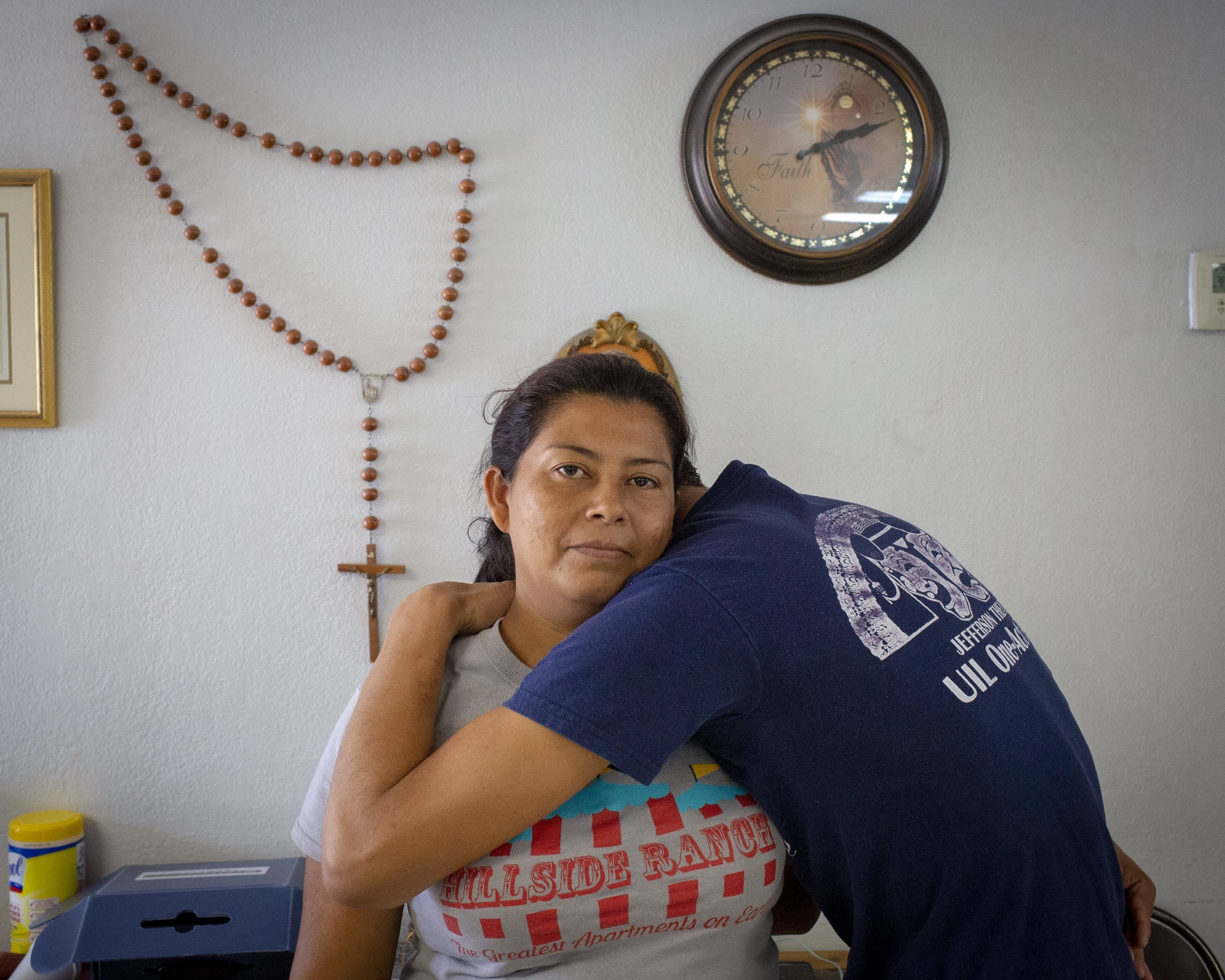  A woman from Central America holds her 16-year old son at a refugee center in McAllen TX. She told me that God told her to come to the United States. Nothing happened to her and her son. She believes that God was watching over them on their journey. (Kevin C Downs/Agence Cosmos) 