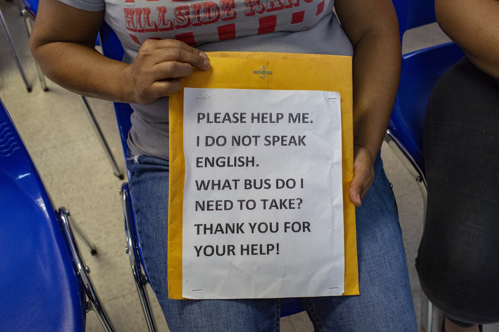  I met a Central American migrant woman and her son from Catholic Charities in McAllen, Texas, who just got released from detention. The woman holds a sign that says " Please help me I do not speak English." This sign will help them as they travel across the U.S. to join other family members. (Kevin C Downs/Agence Cosmos) 