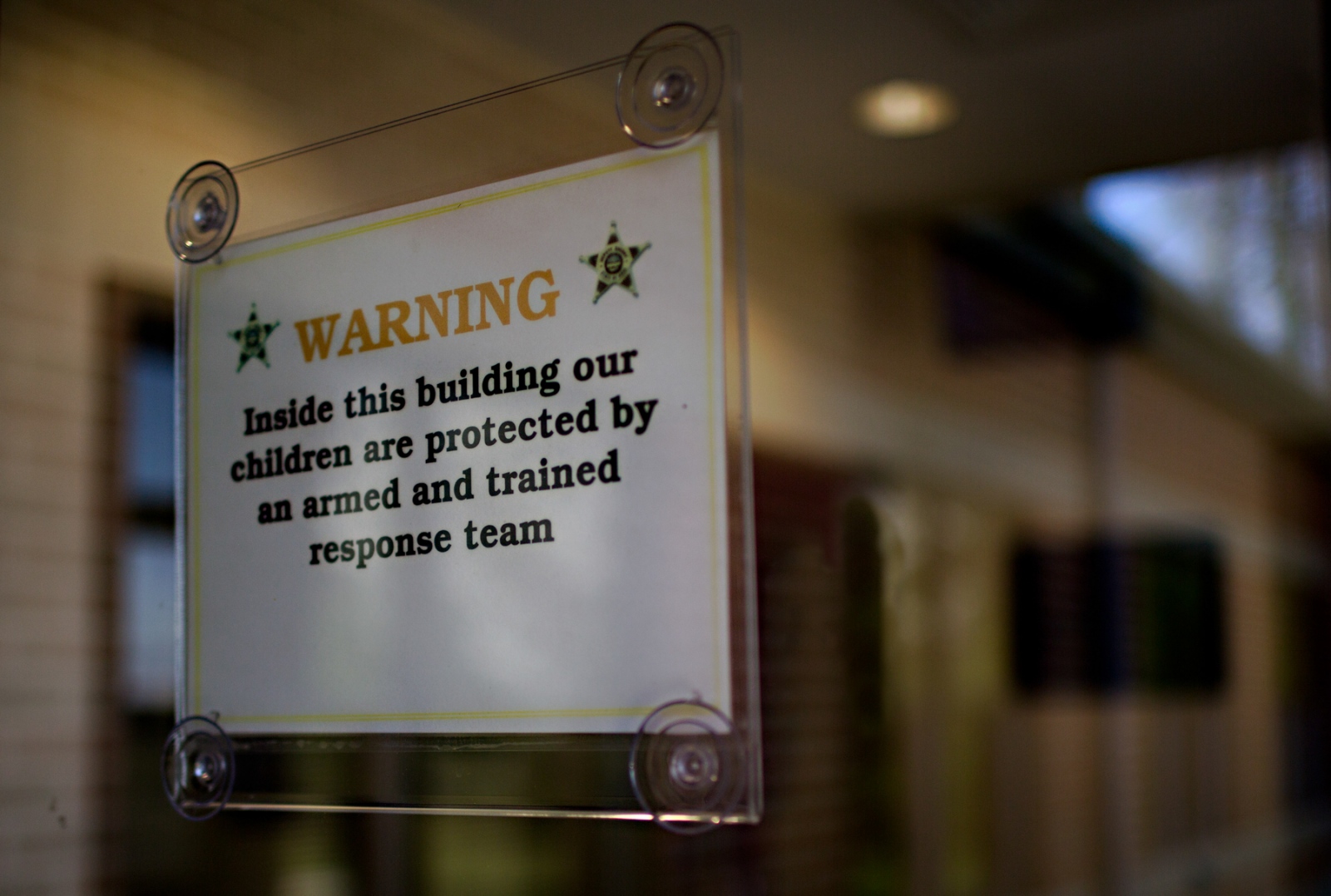  A sign on the front doors of t...be met with an armed response. 