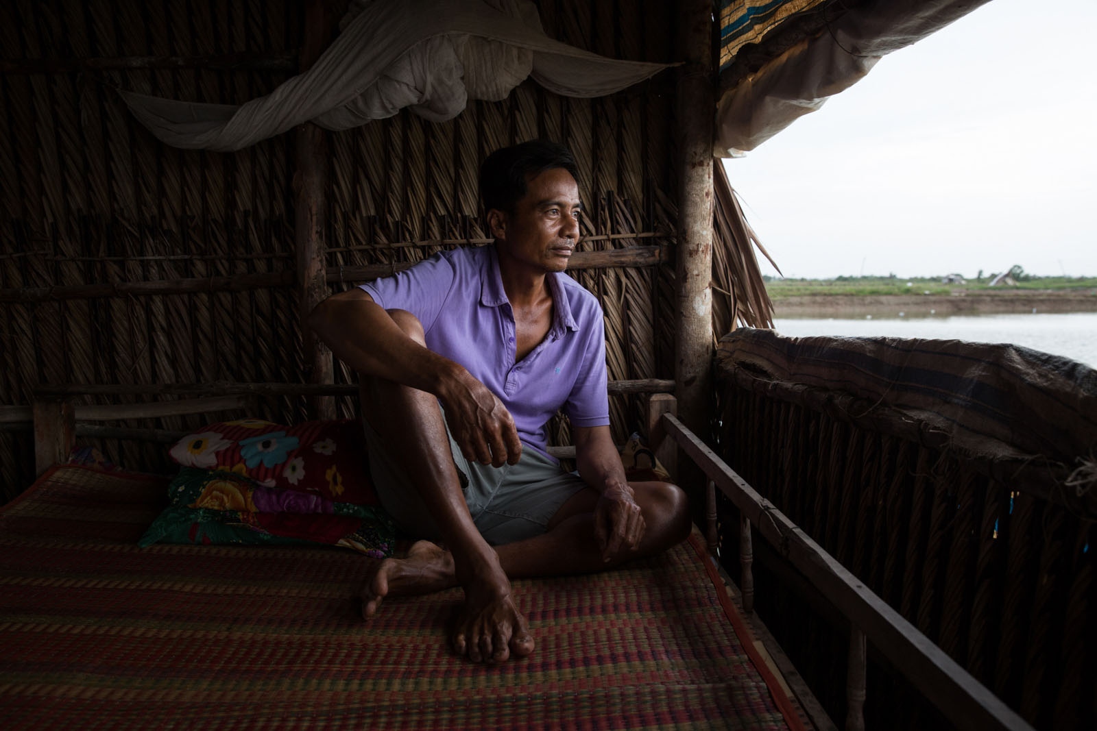 A DAMAGED DELTA -  Shrimp farmer Ly Sa Luong sits in his small shack next...