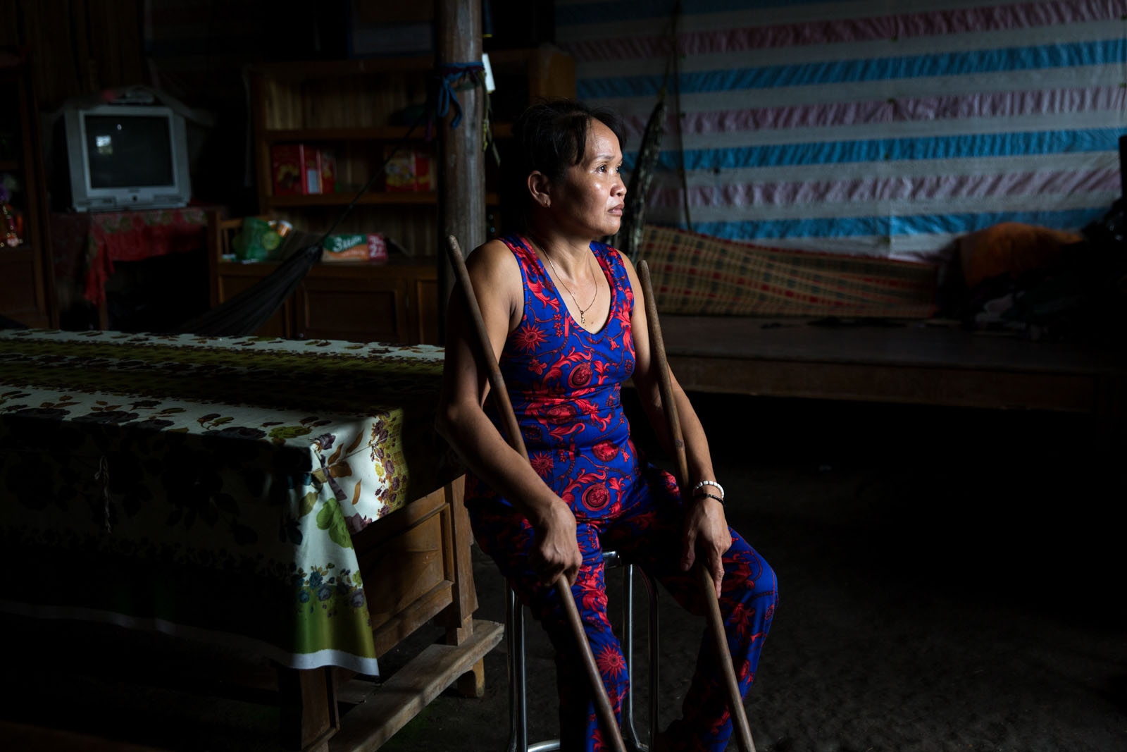 A DAMAGED DELTA -  Ex-rice farmer Nguyen Tuyet Khanh sits in the main room...