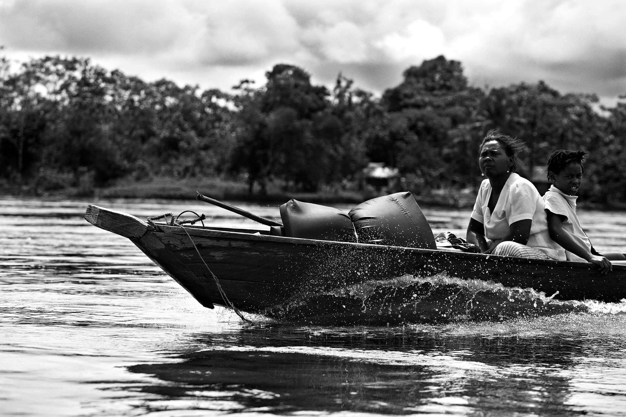 Forced Displacement in Chocó - A woman and a girl sail in one of the boats that take the...