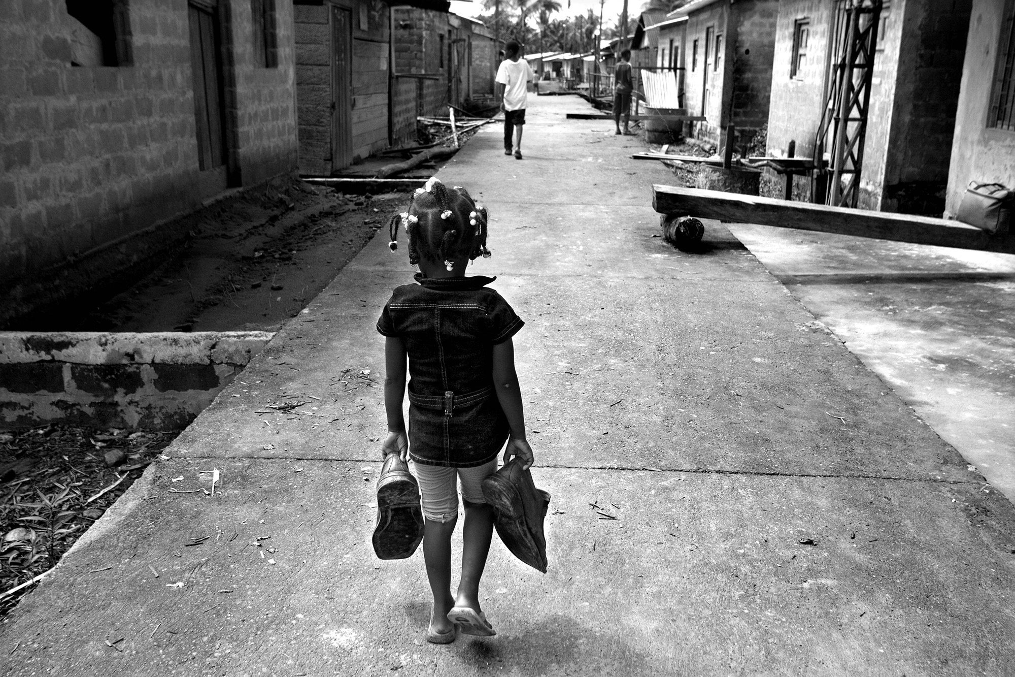 Forced Displacement in Chocó - A girl walks with her father's shoes, the day of...