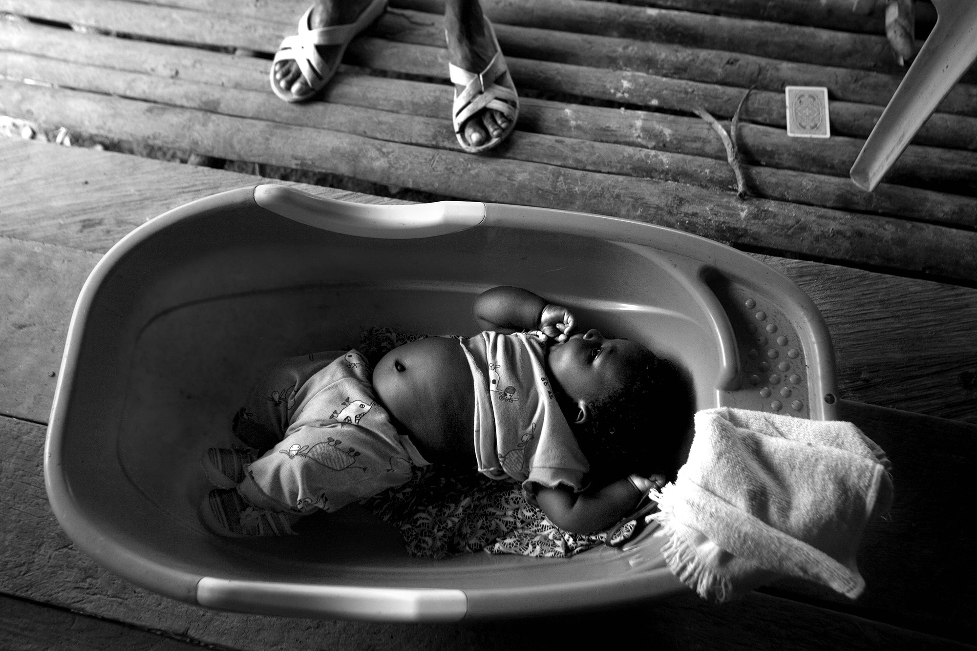Forced Displacement in Chocó - A baby rests in a plastic tub in the middle area of San...