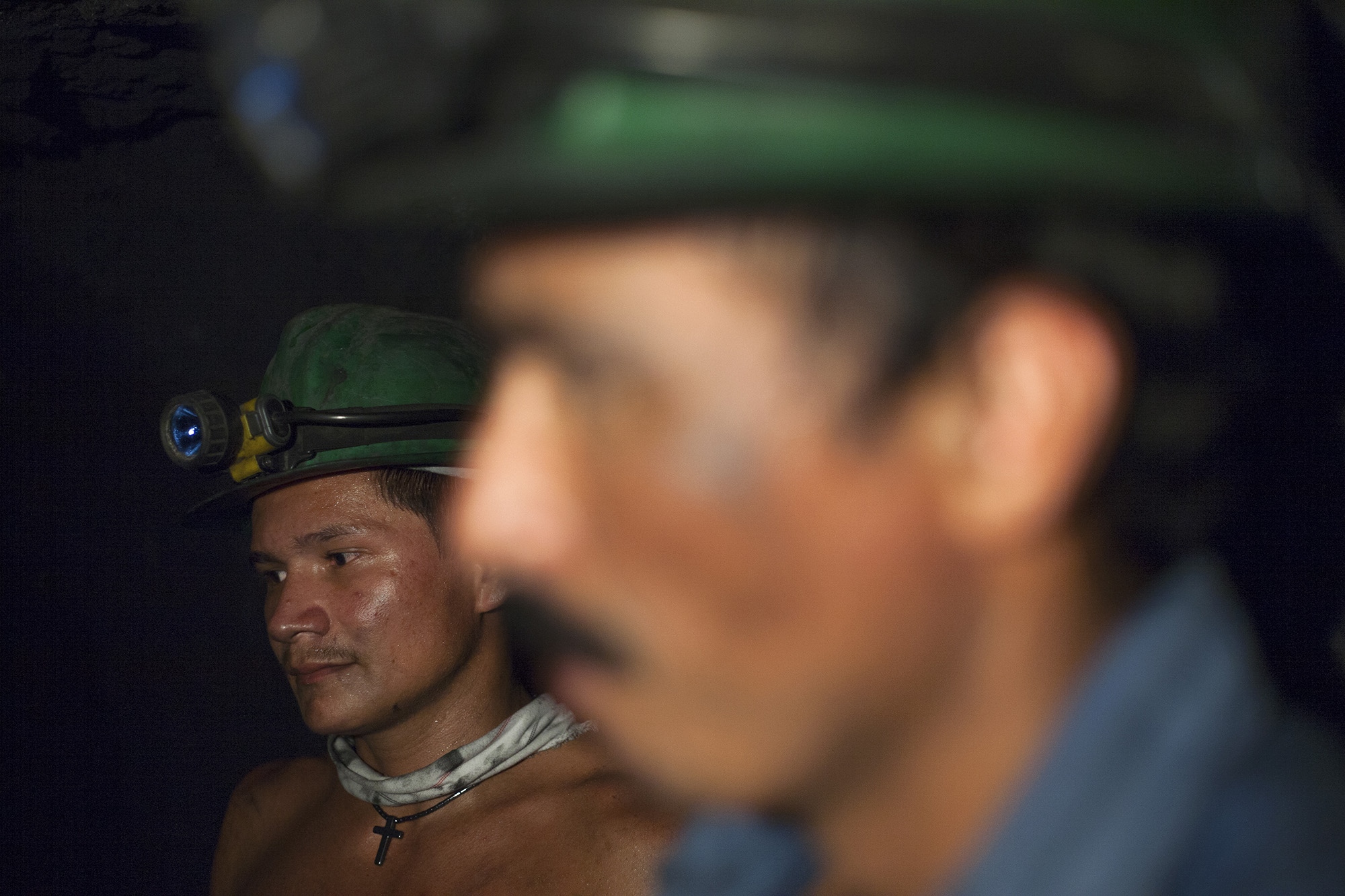 Two miners work inside an emerald mine in the Muzo region, Boyac&aacute;, Colombia.