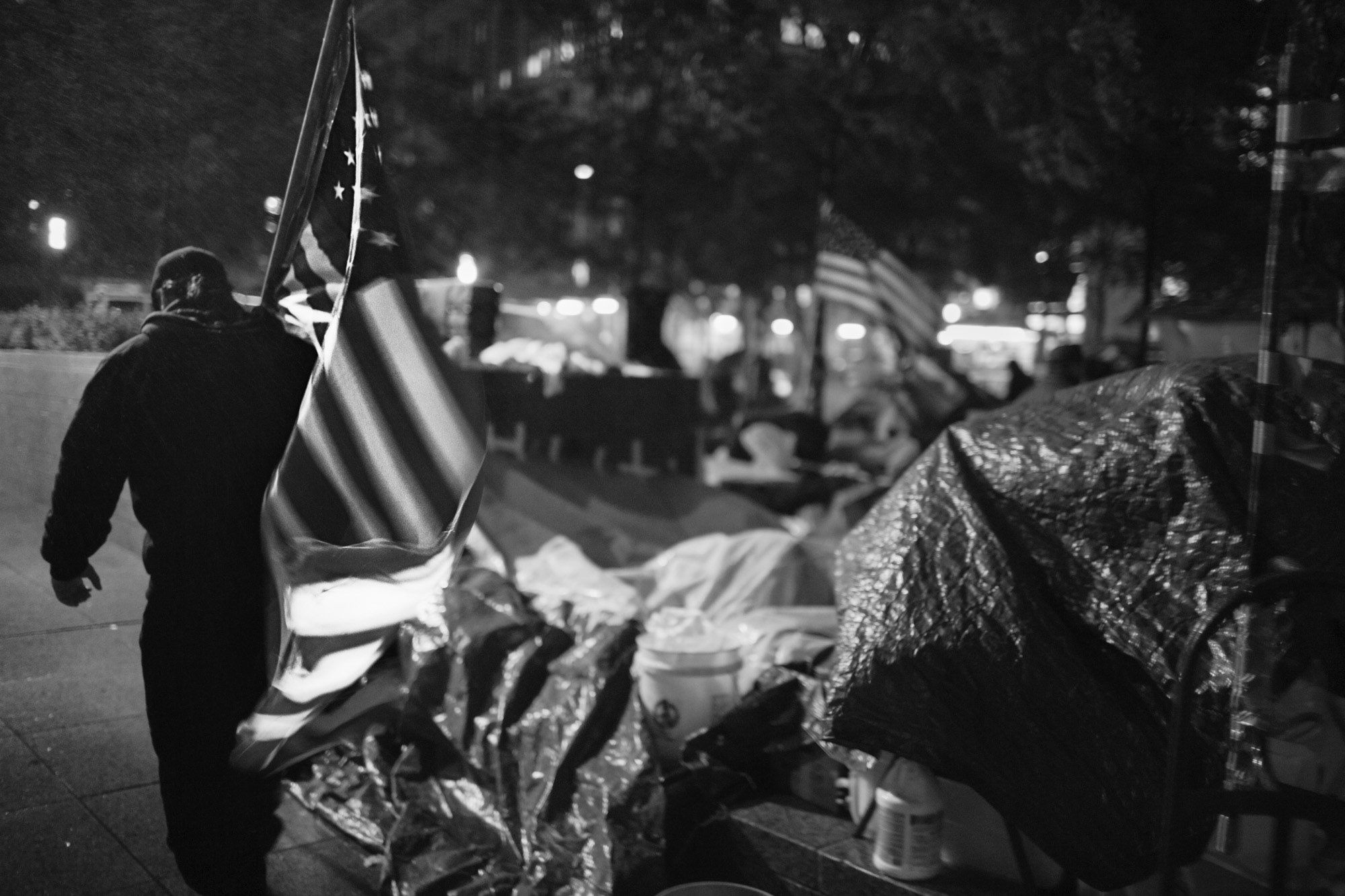 Occupy Wall Street -  An OWS protestor carries an American flag through the...