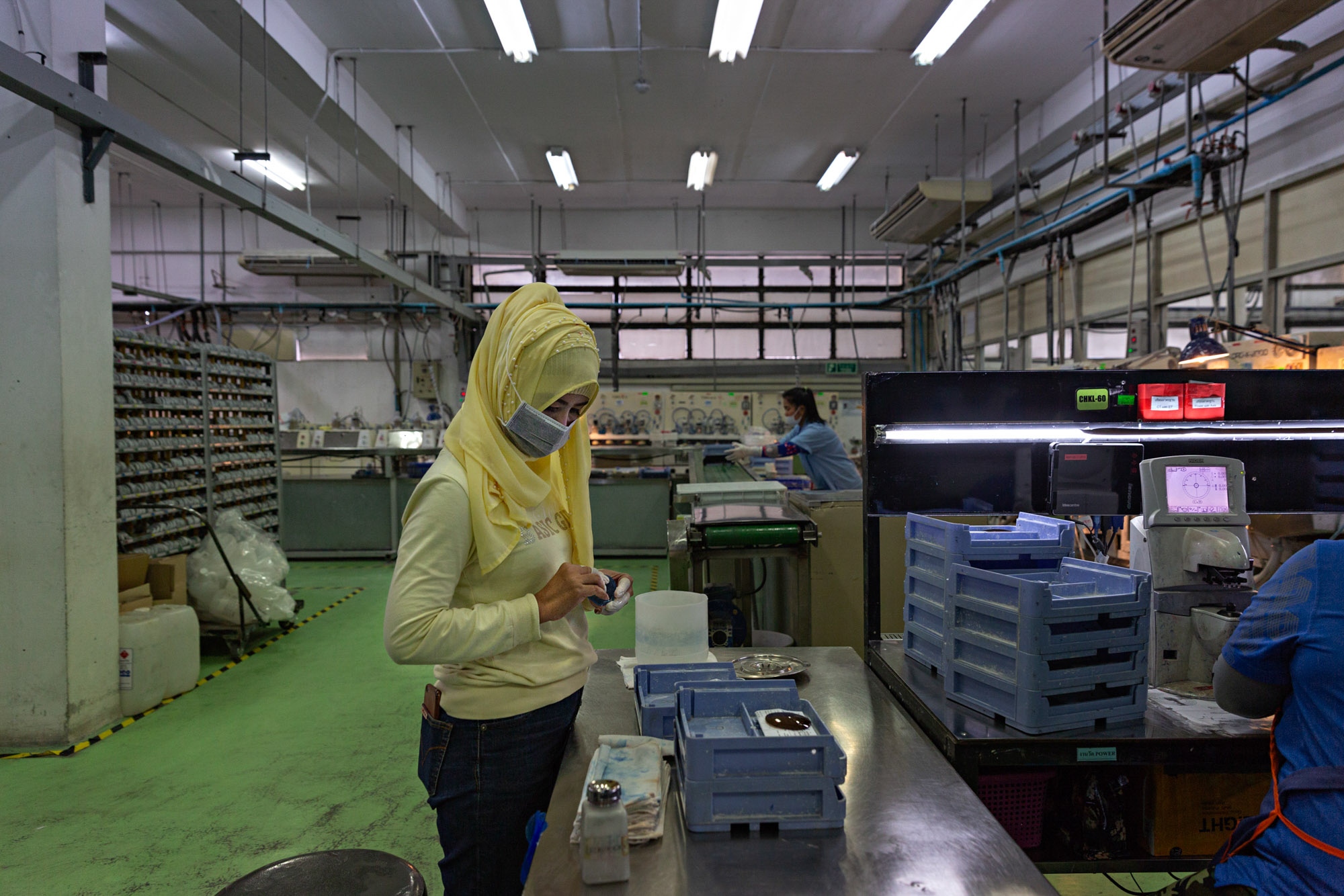 Thailand Glasses Factory: Stern - An employee checks lenses before sending them along the...