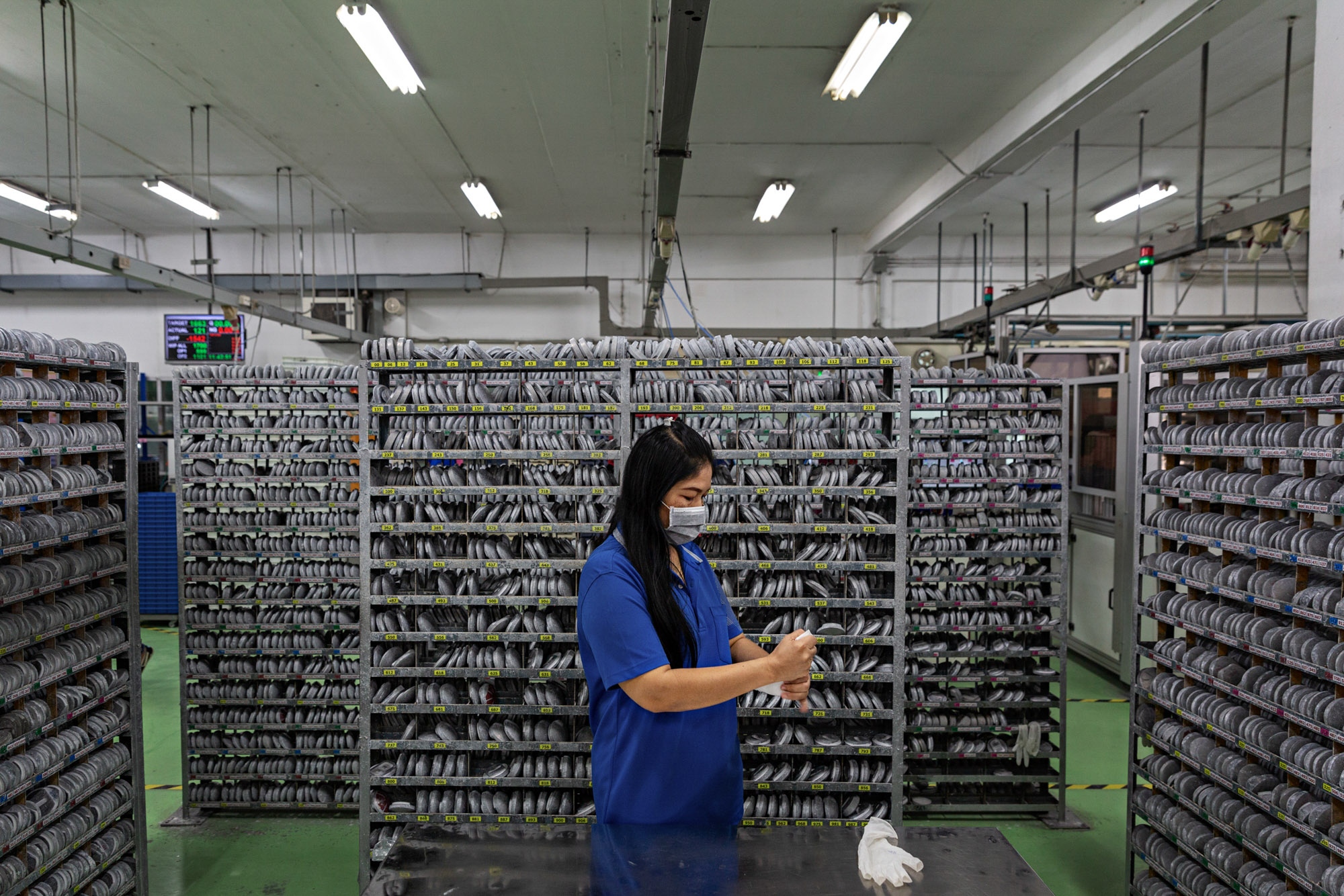 Thailand Glasses Factory: Stern - An employee removes her gloves at Brille24’s old...