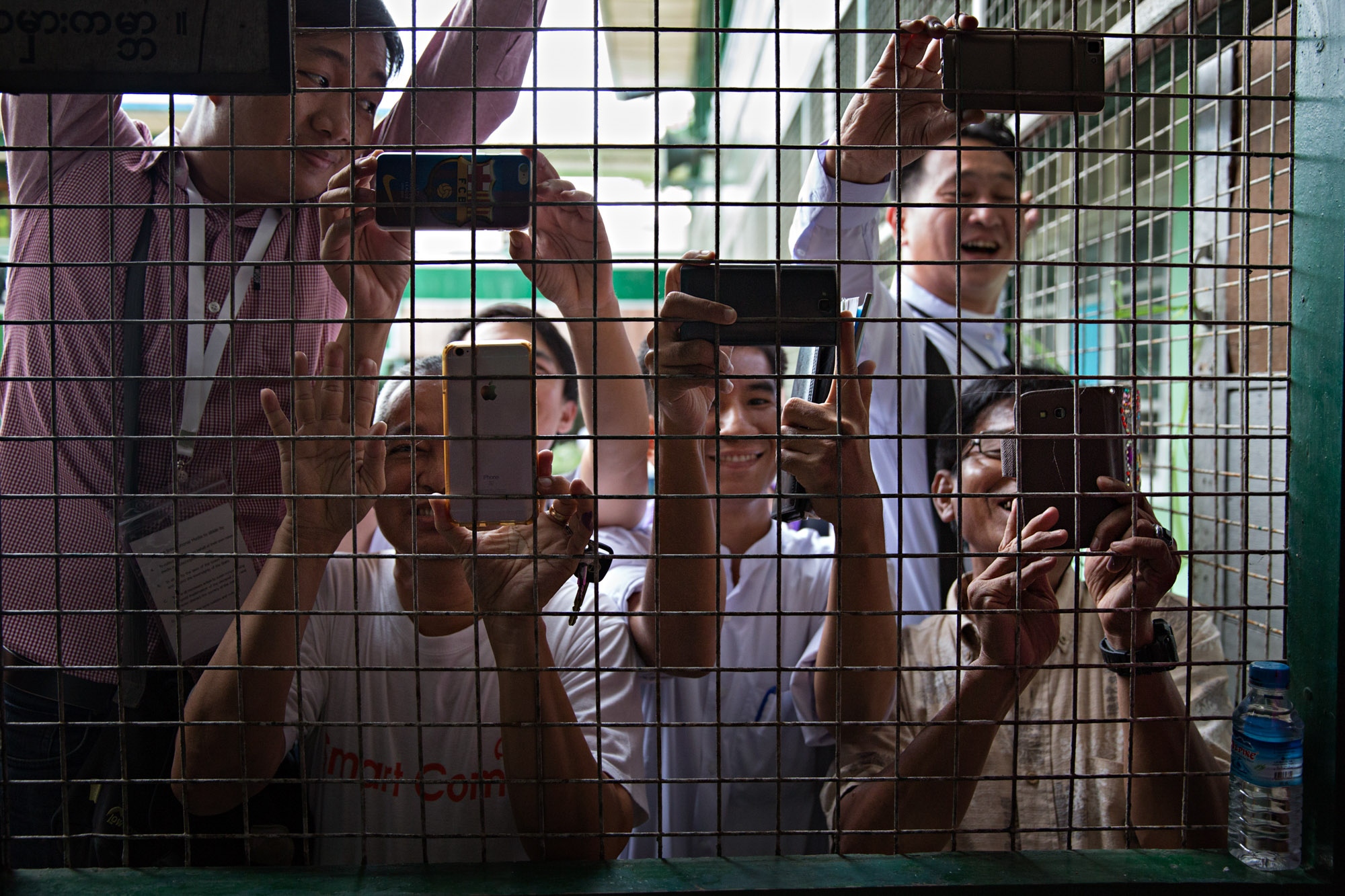 NLD (National League for Democracy) supporters try to get phone images of Aung San Suu Kyi as she arrives to cast her vote in Yangon, Myanmar,...