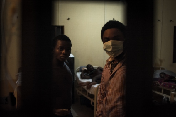 Image from No Room For Lassa -  Just before they go to bed, two young men look out of...