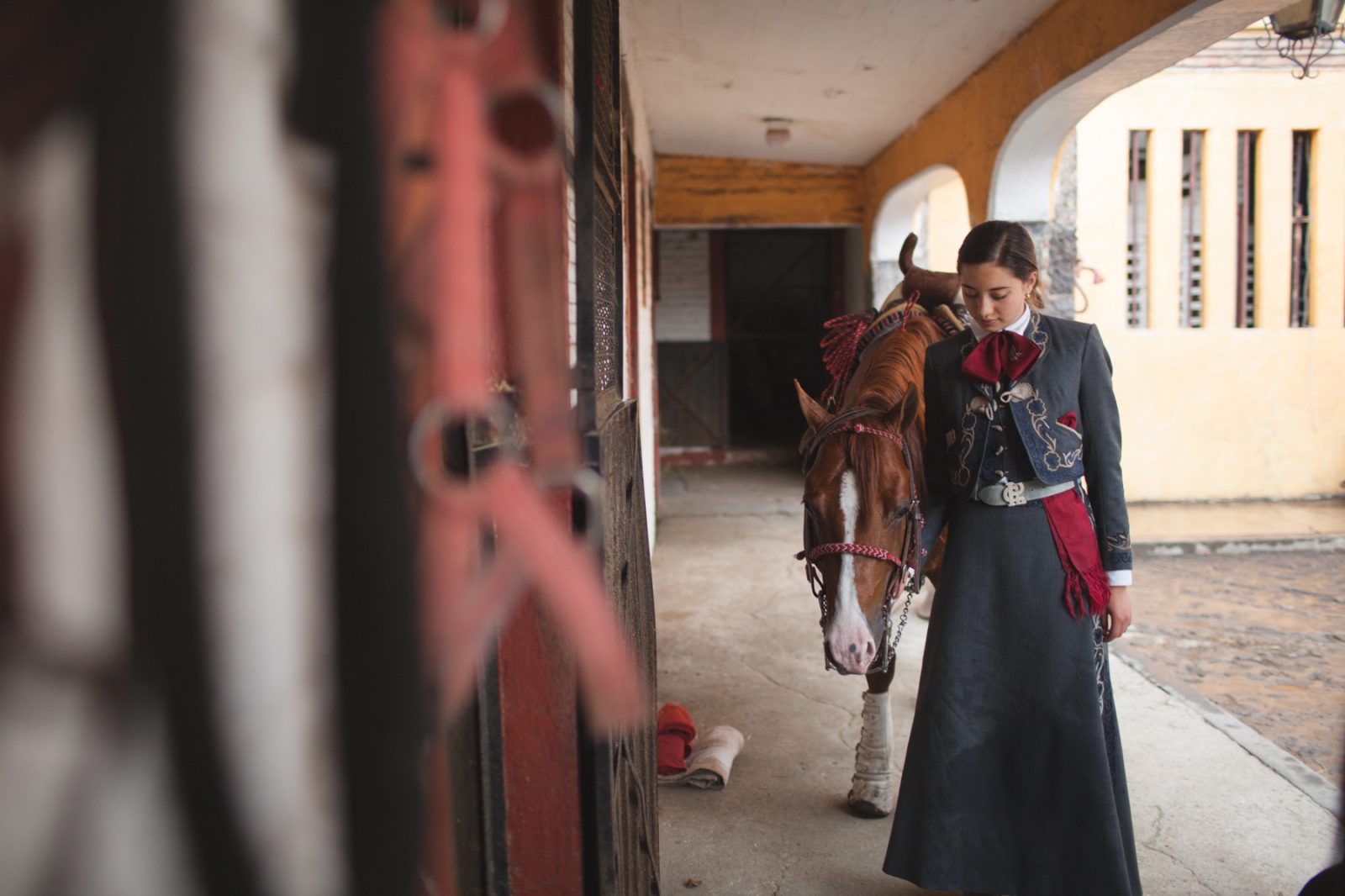 Image from Portraits - An escaramuza tends to her horse at the Lienzo Charro del...