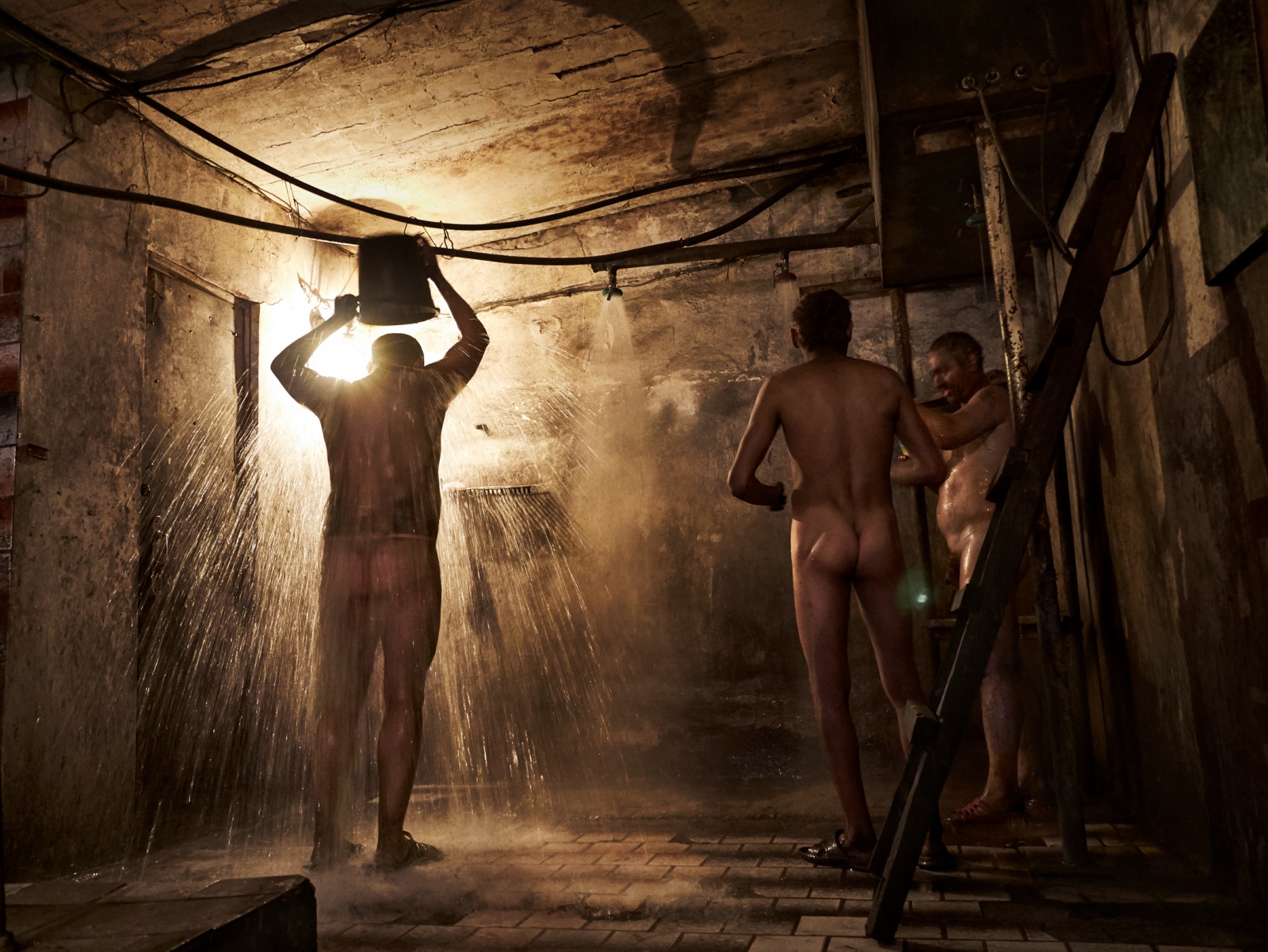 Miners taking a shower after a long day of work in an illegal coal mine. 