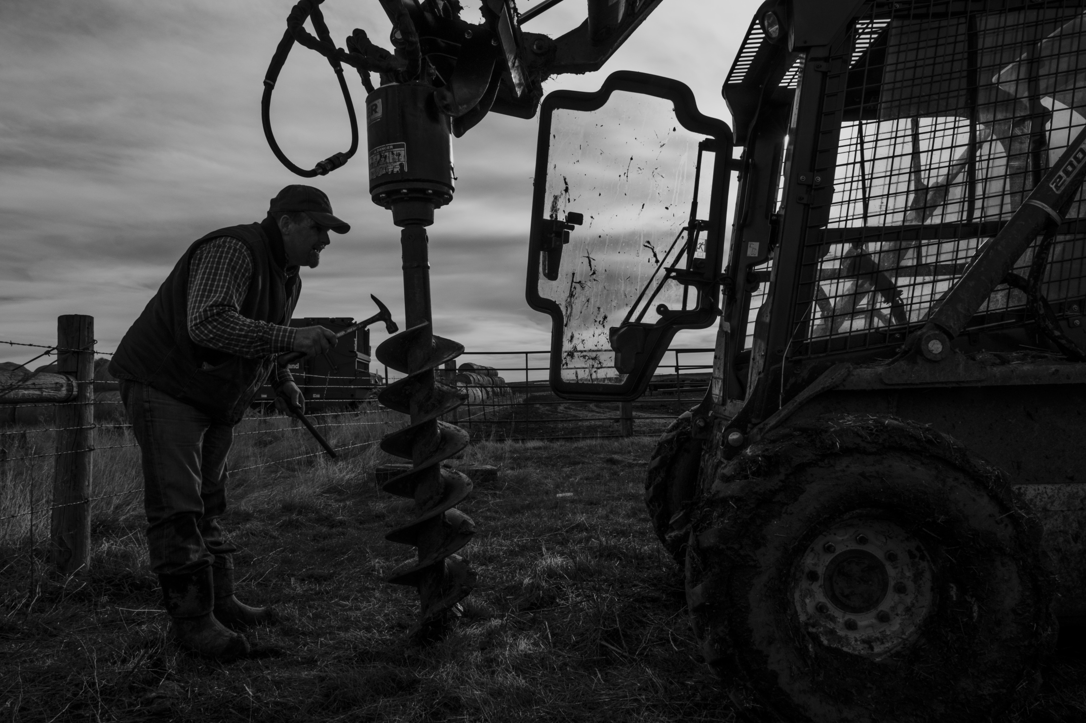  Jess Starr fixes his machinery before drilling holes and setting up fencing. Most ranchers are...