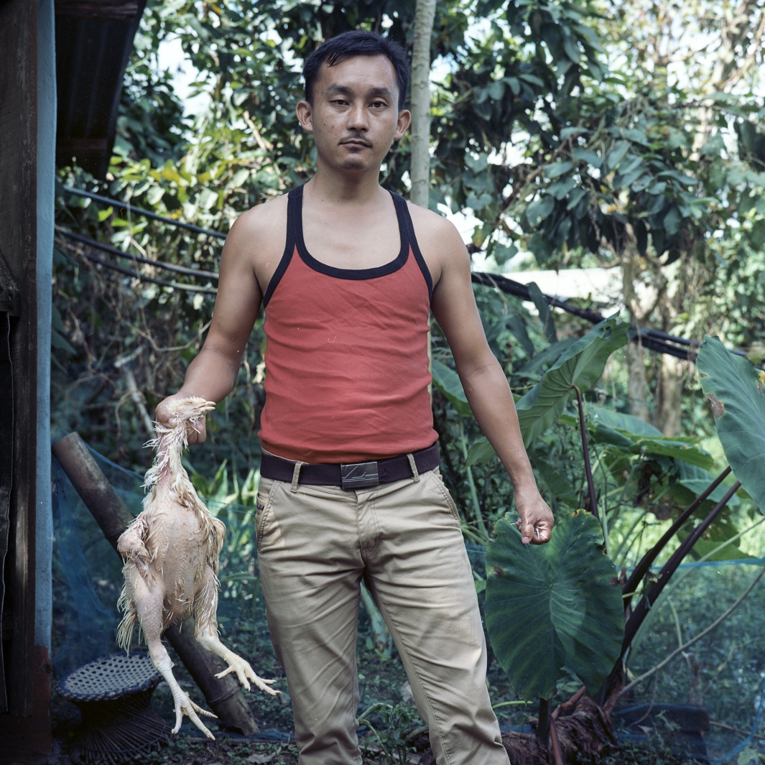  Salam Enao Meitei, 30. Thanga Tongbram Leikai, Manipur Salam Enao Meitei, a poultry owner, poses for a portrait while preparing a meal for a luncheon. The younger generation in communities surrounding Loktak is moving away from the traditional livelihood of fishing because making a living from fishing has become challenging. The older generation has been encouraging the younger generation to get an education to find a different means of livelihood. 