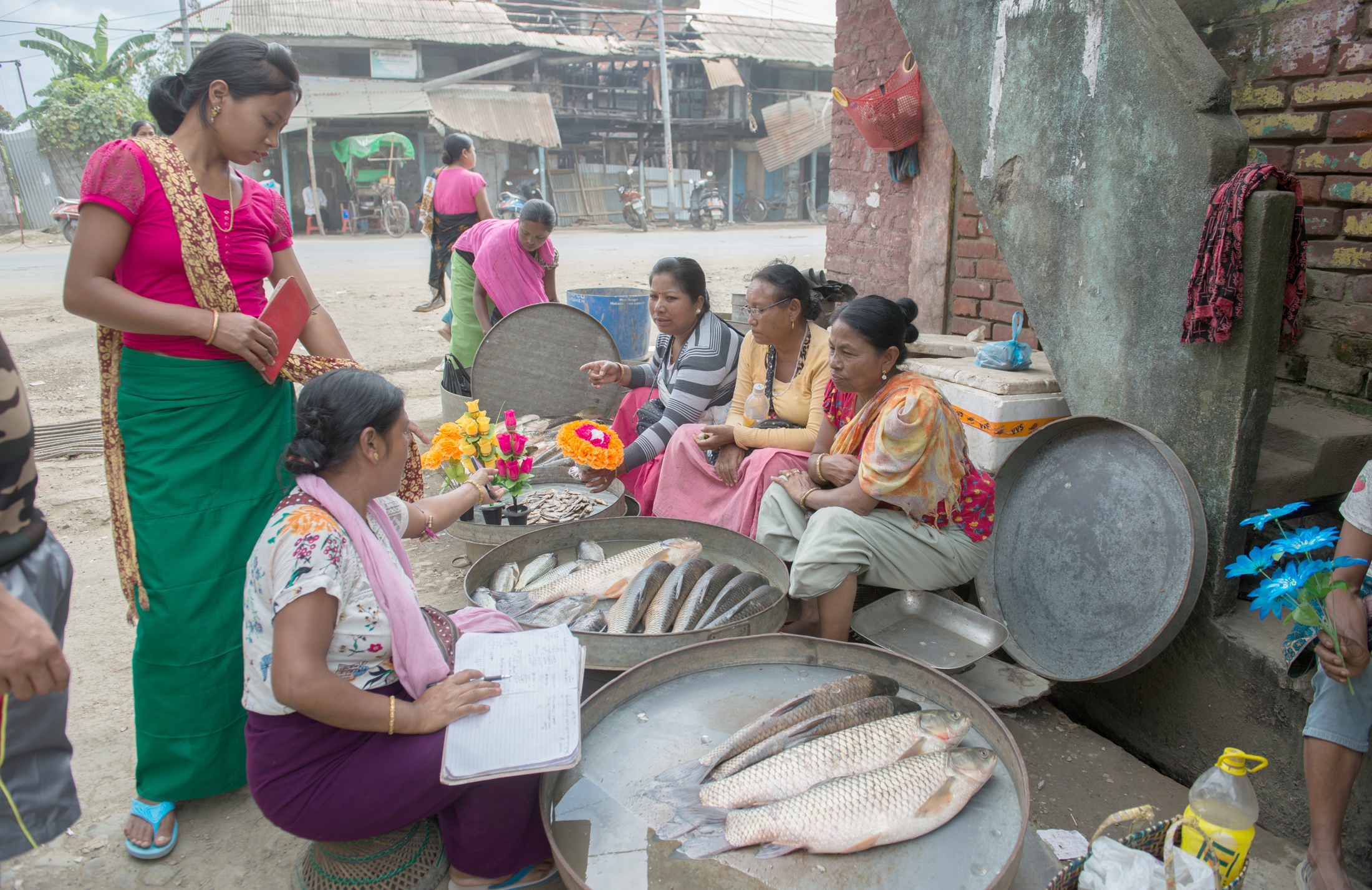  Fisherwomen and vegetable vendors wrap up business for the day in the Ema market in...