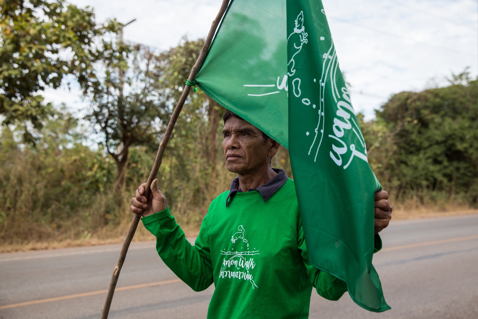 WHAT LIES BELOW SHOULD STAY BELOW - A villager member holds a Wamon Walk flag during the...