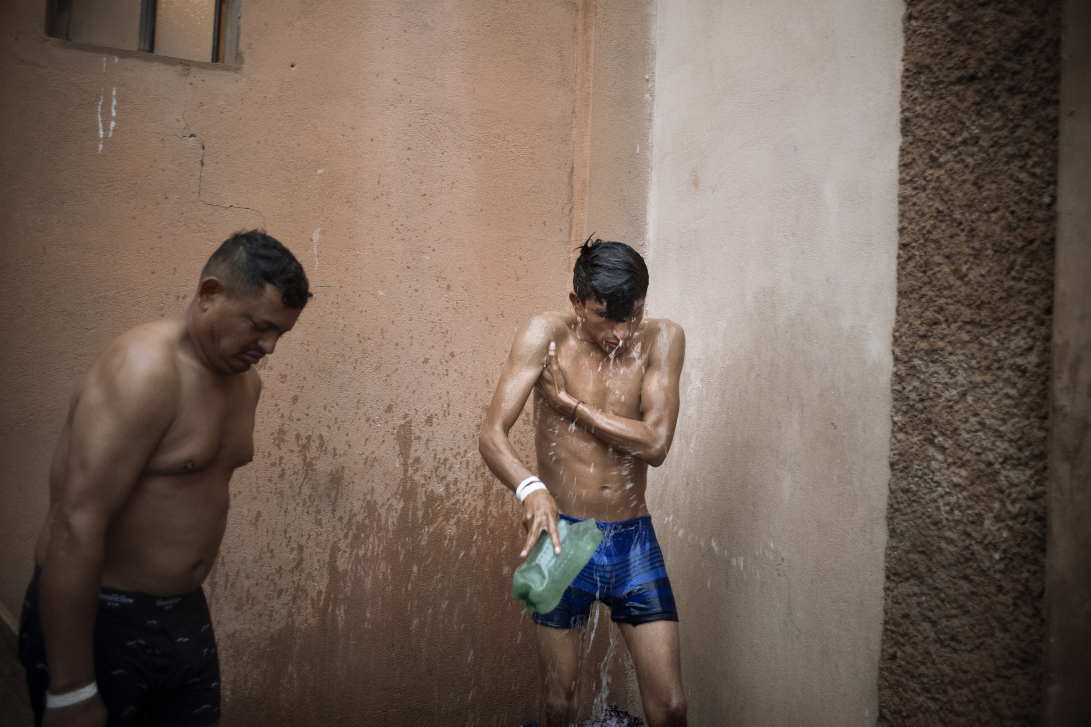 Por que nos Fuimos (Why We Run) - Asylum seekers rise with the sun to rinse in the cold,...