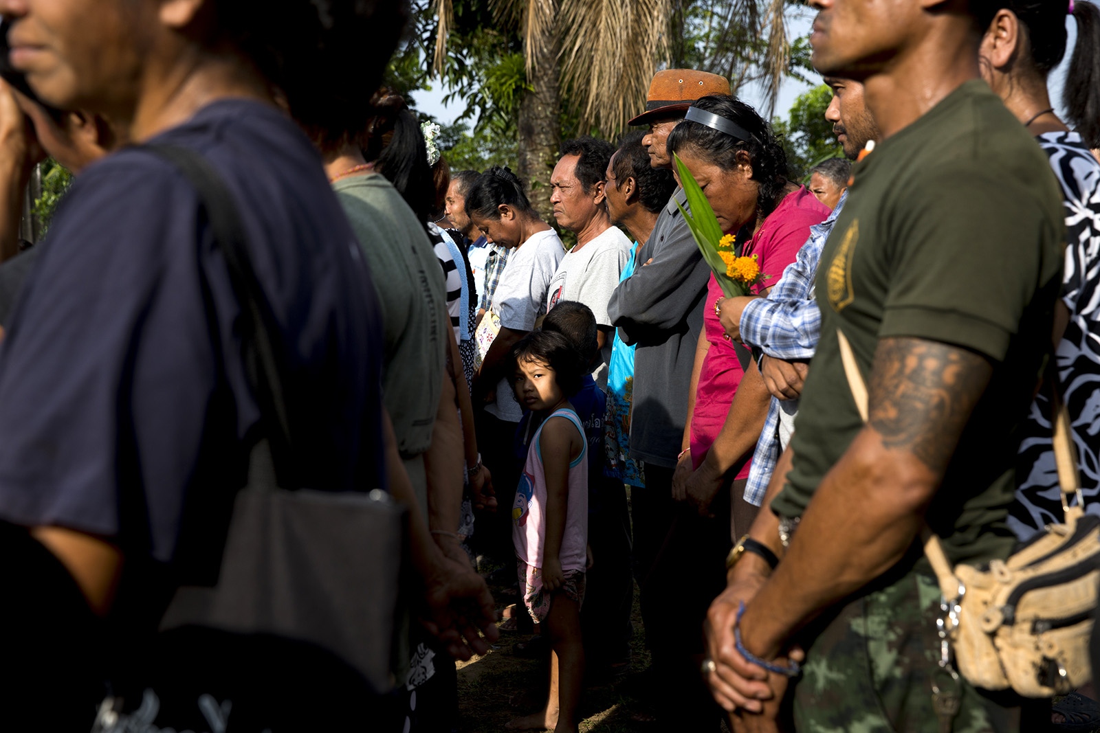 A VILLAGE UNDER SIEGE - Villagers stand for one minute of silence on November...