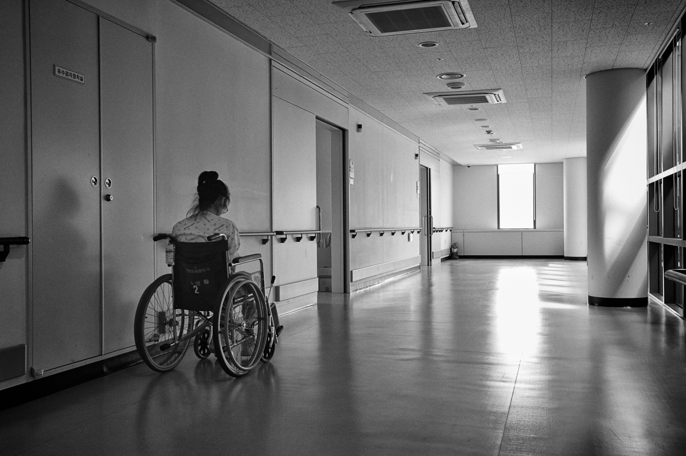 Another Family -   Han Hye-kyung sits on a wheelchair on a corridor at...