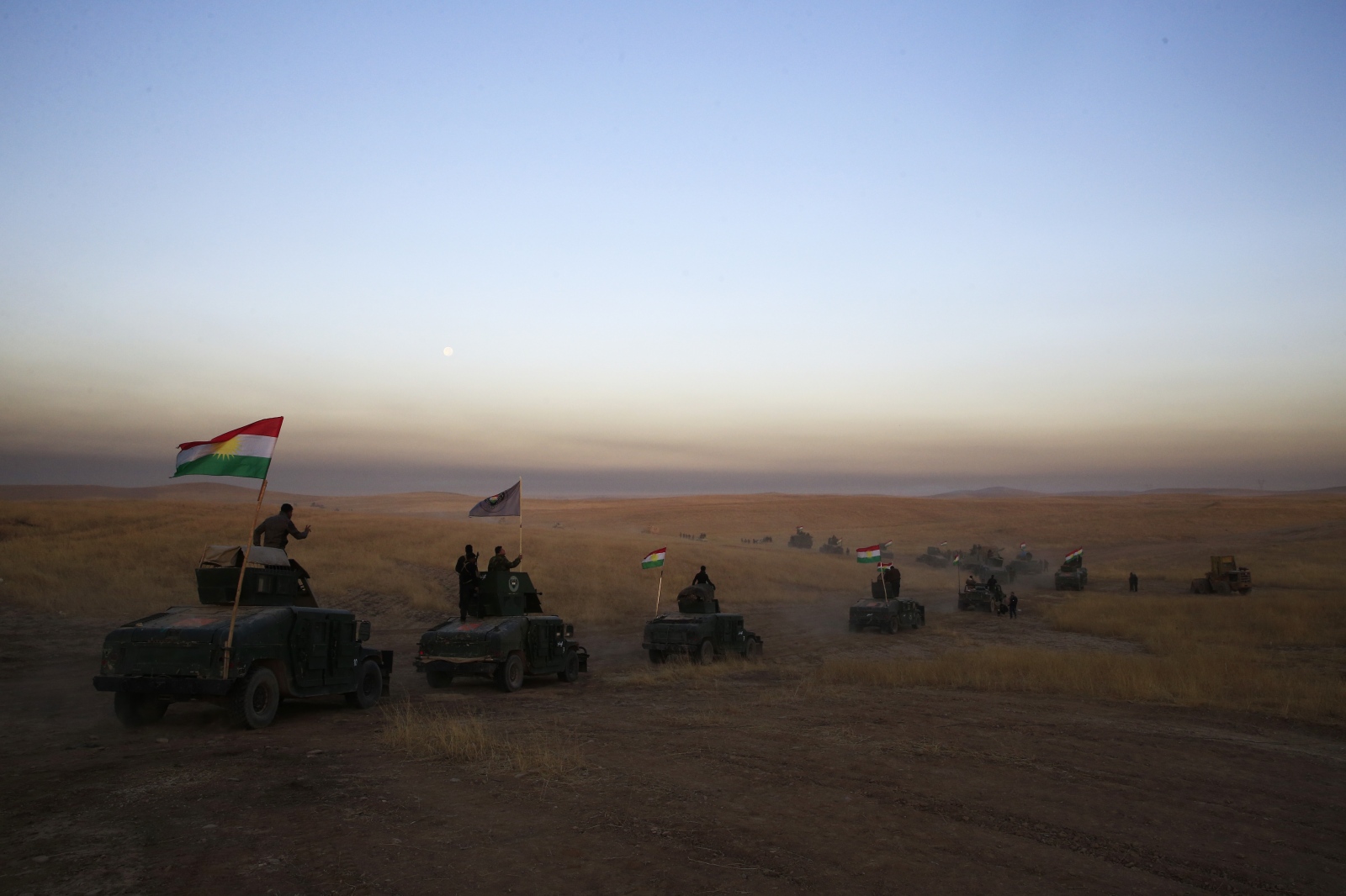 A Kurdish Peshmerga convoy drives towards a frontline. The Iraqi military and the country&rsquo;s Kurdish forces say they launched operations to the south and east of militant-held Mosul early Monday morning.