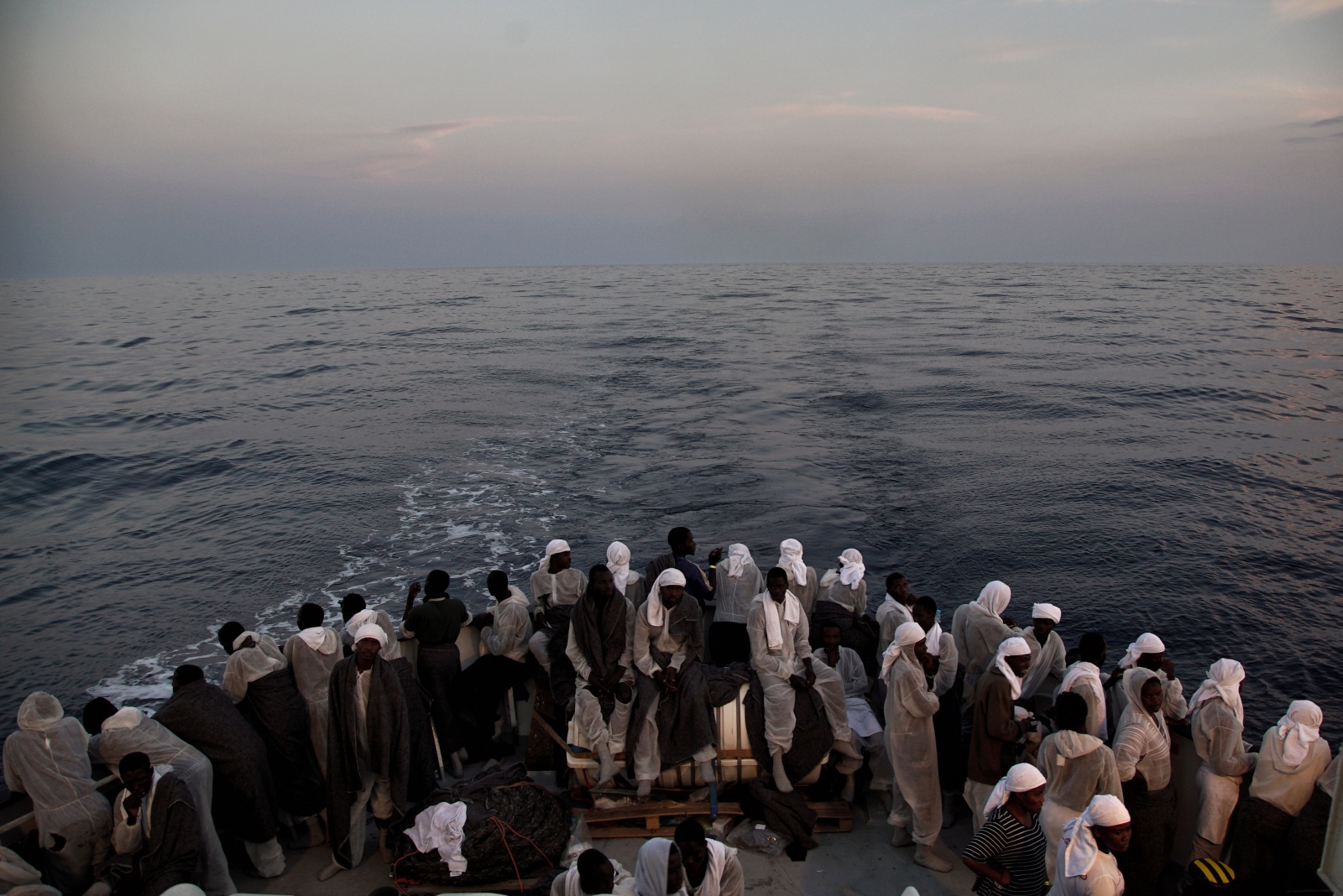 Migrants look out from the stern of the &#39;Aquarius&#39; vessel, on the Mediterranean Sea, with more than 600 migrants aboard the ship rescued by SOS Mediterranee and the medical aid group Medecins Sans Frontieres (MSF).