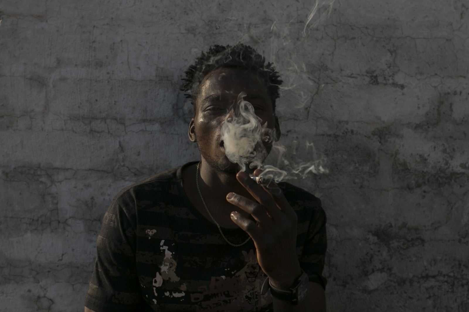 Malawian migrant Jonas smokes m...doned building. March 29, 2018.