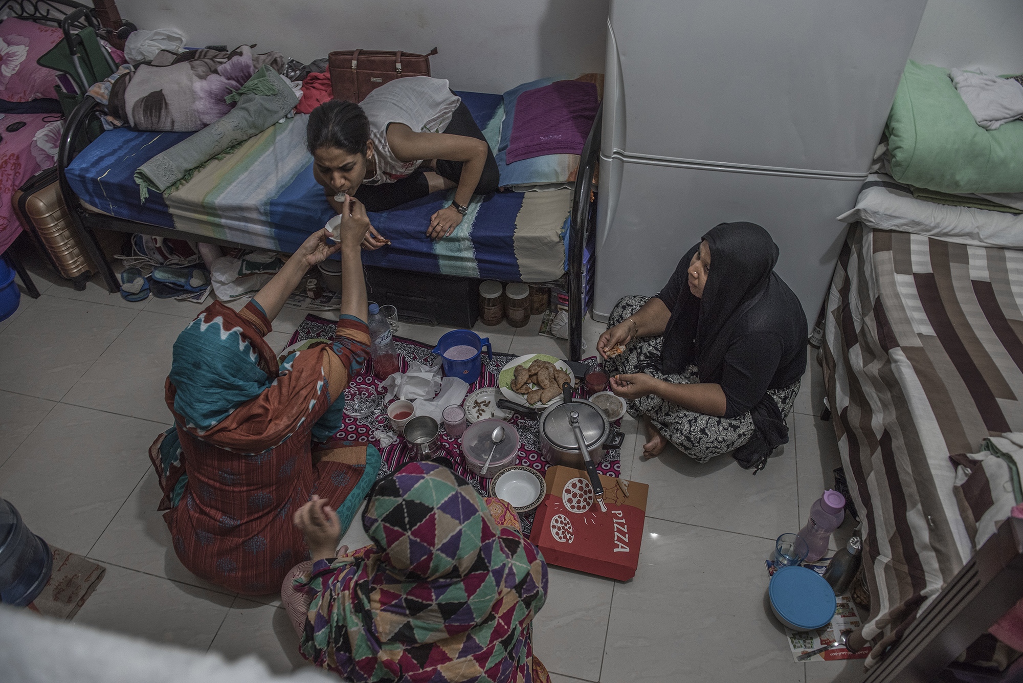 Migrant Women in the UAE -  During weekend mothers dine on a floor in their...
