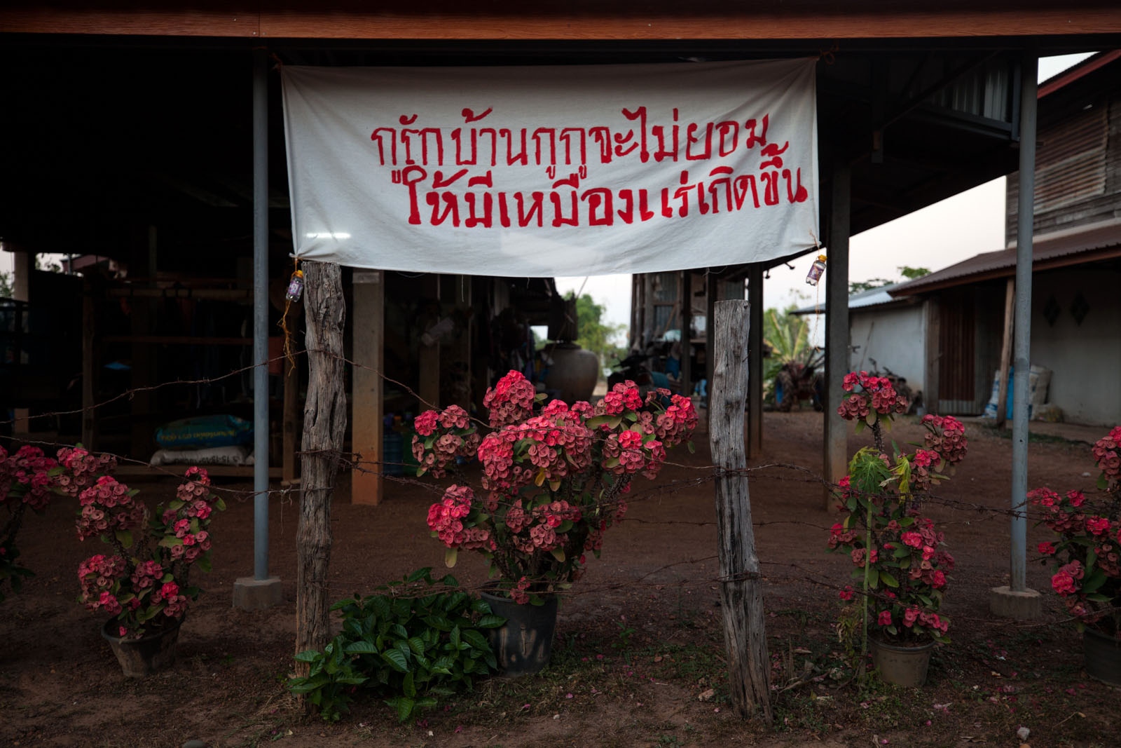 WHAT LIES BELOW SHOULD STAY BELOW - A anti-mining sign written in Thai reads "We love...