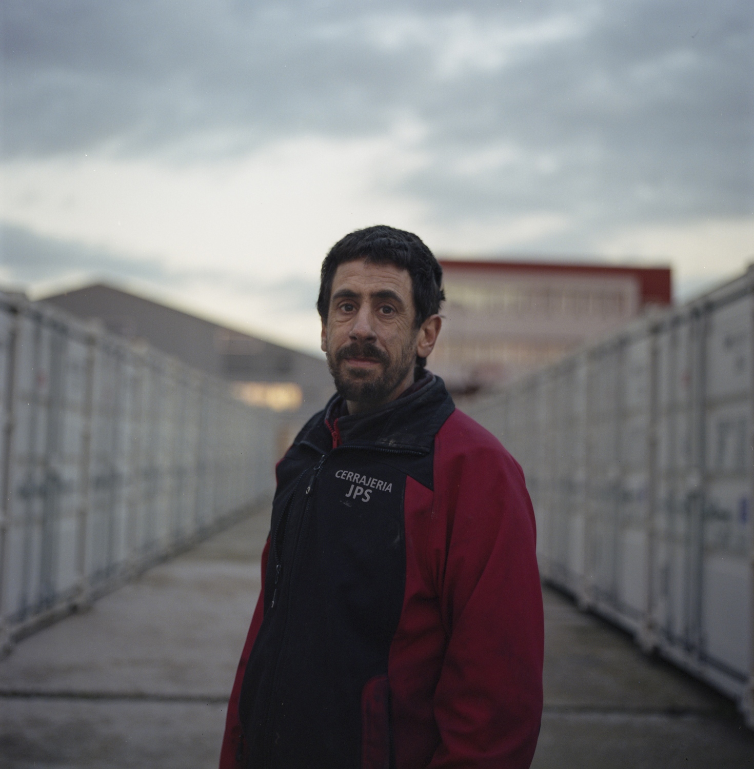 Jose poses for a portrait in a shipping container yard he manages the security for. Speaking of...