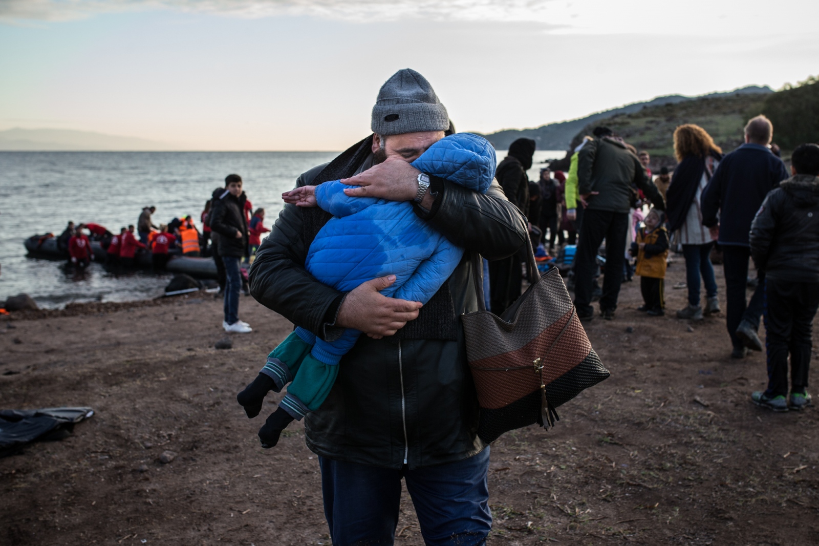 A refugee man hugs his son on t...ey on the 4th of December 2015.