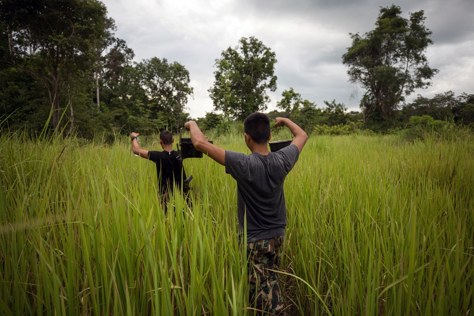 PROTECTING THAILANDS ROSEWOOD - Rangers hold cooking pots full of water collected from a...