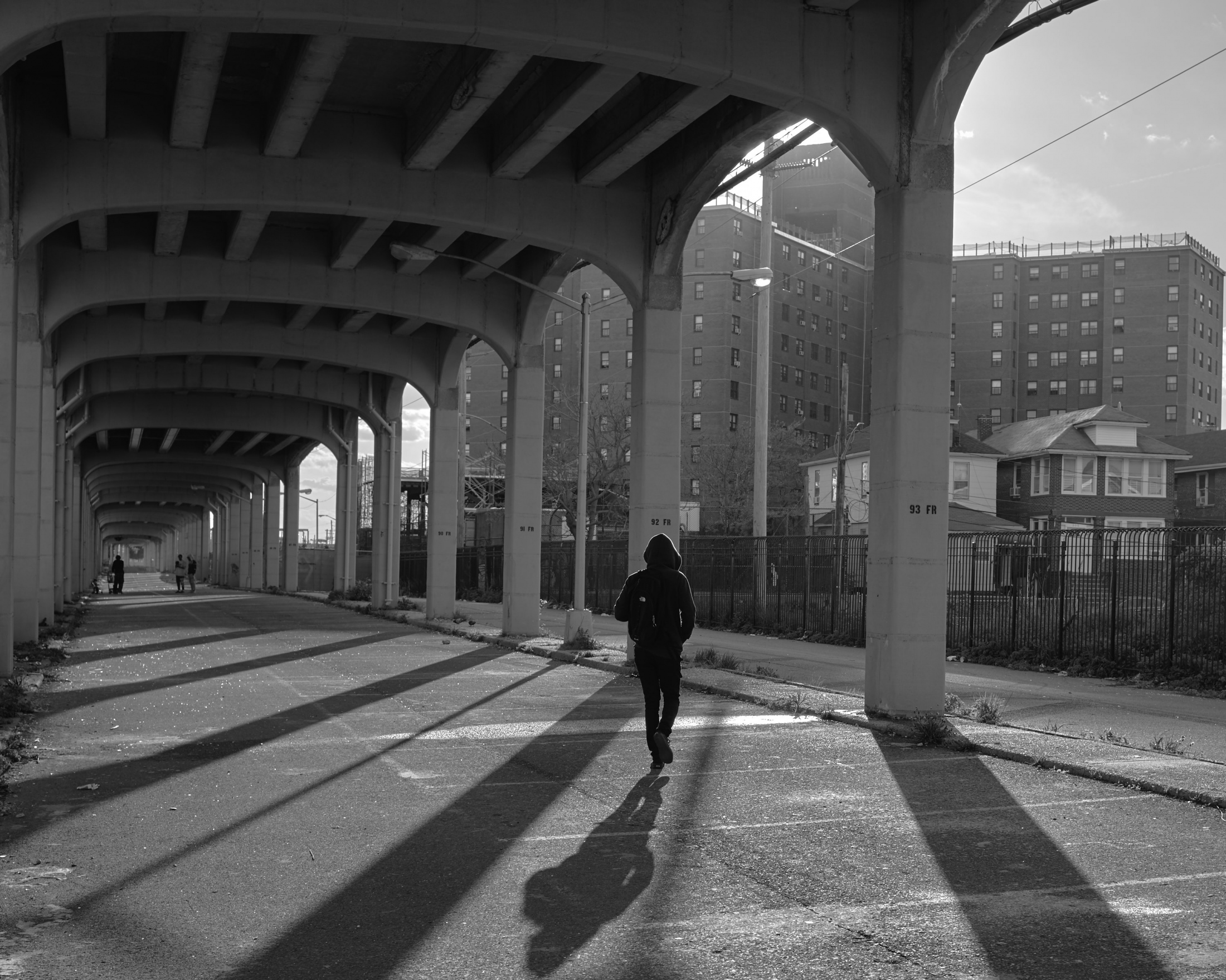 A young boy walks over Arverne, a street that remains closed underneath the train railway system....