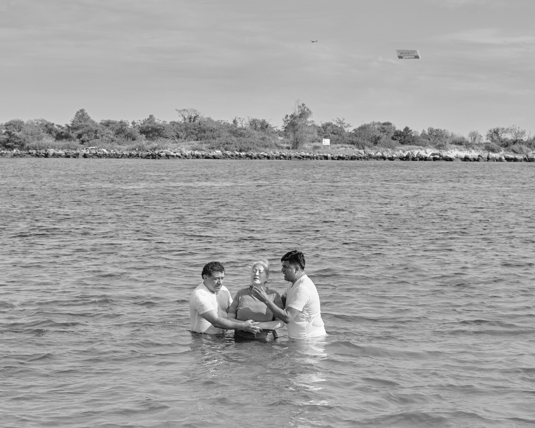 A group of evangelical celebrates a baptism in a Sunday morning, over the Reynolds Channel in Far...