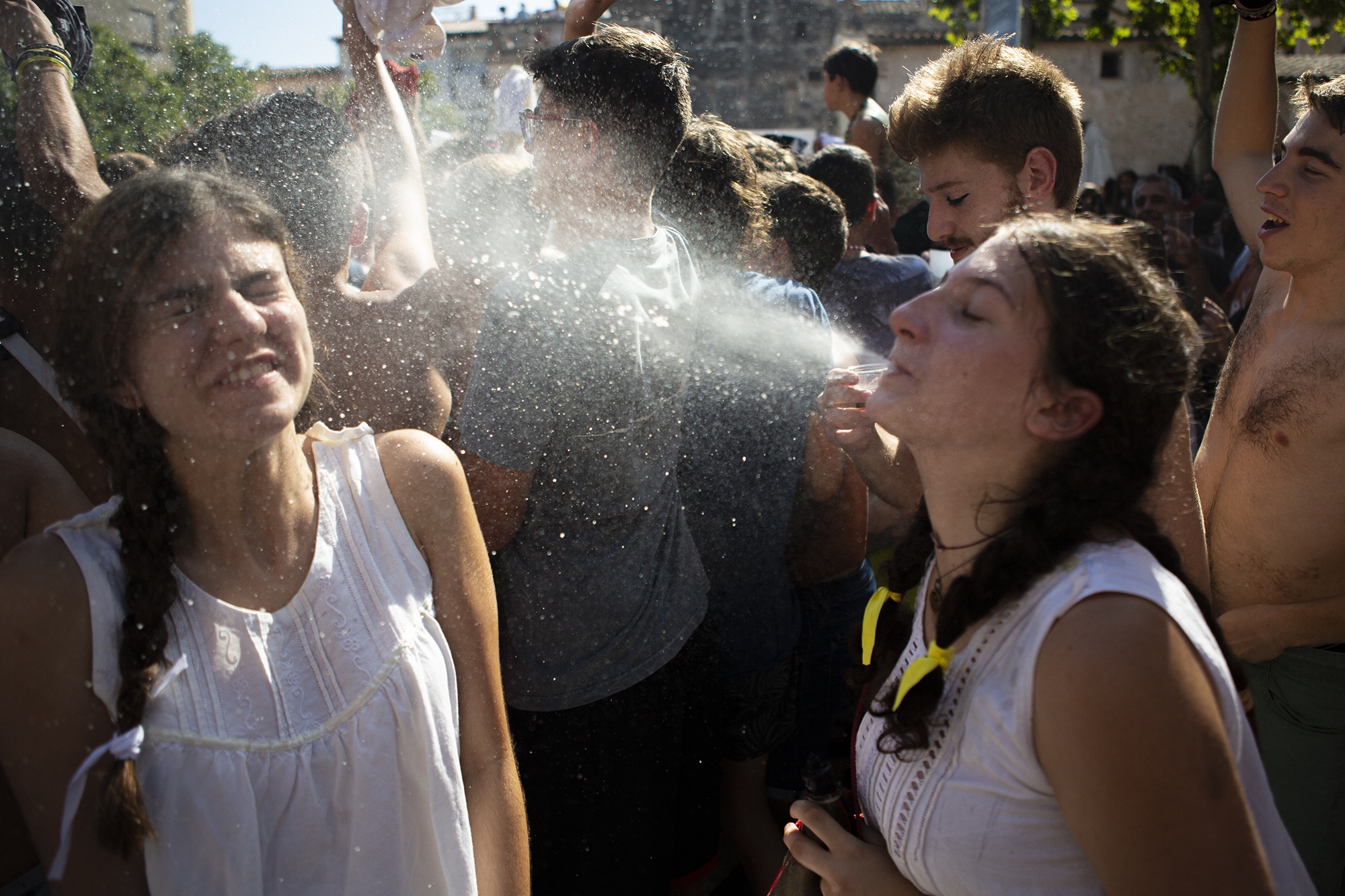 Llucia spray out her friend to battle the heat. Pollen&ccedil;a, Mallorca, August 2 2019.